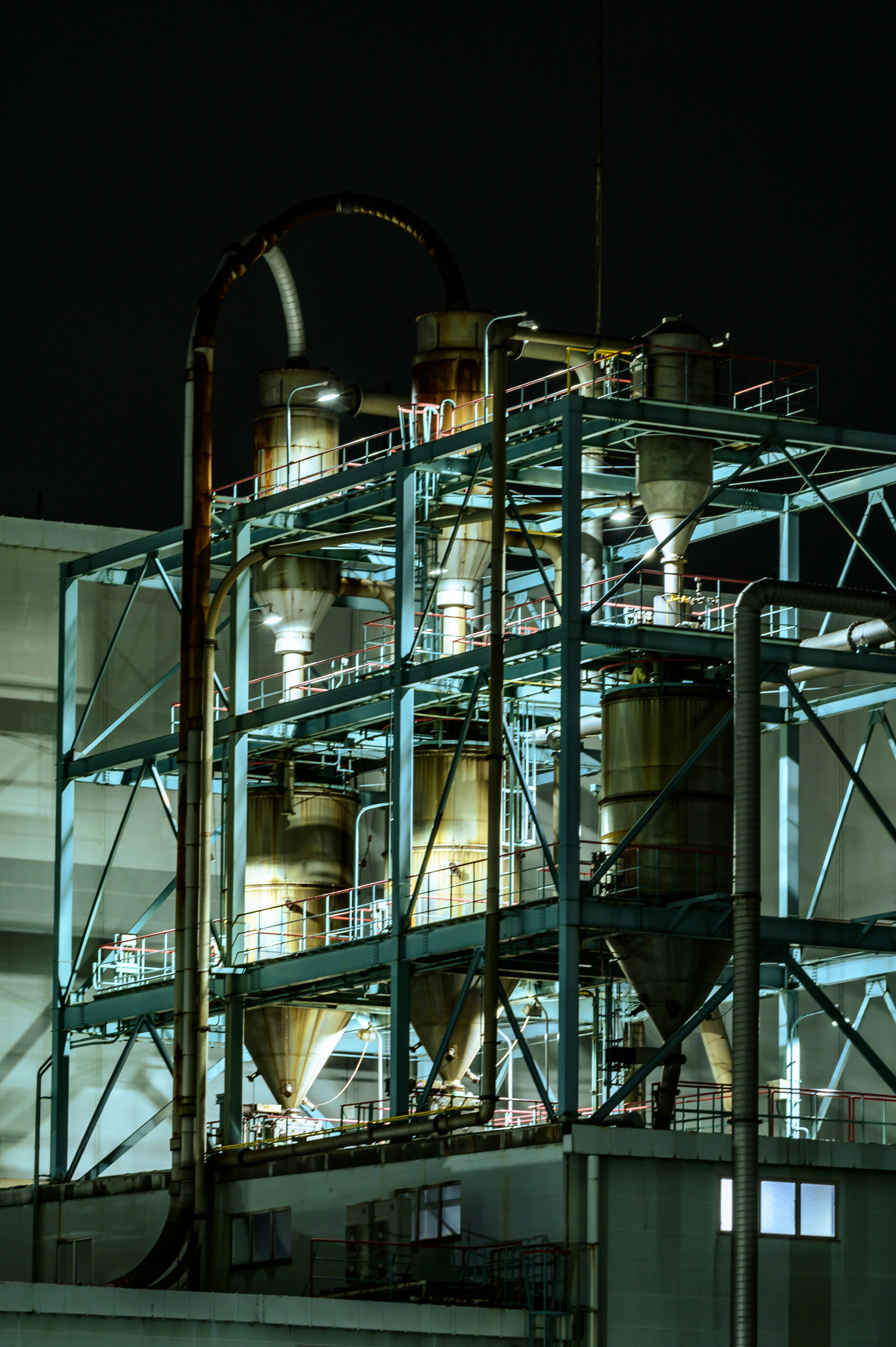 nighttime industrial plant with pipes and equipment