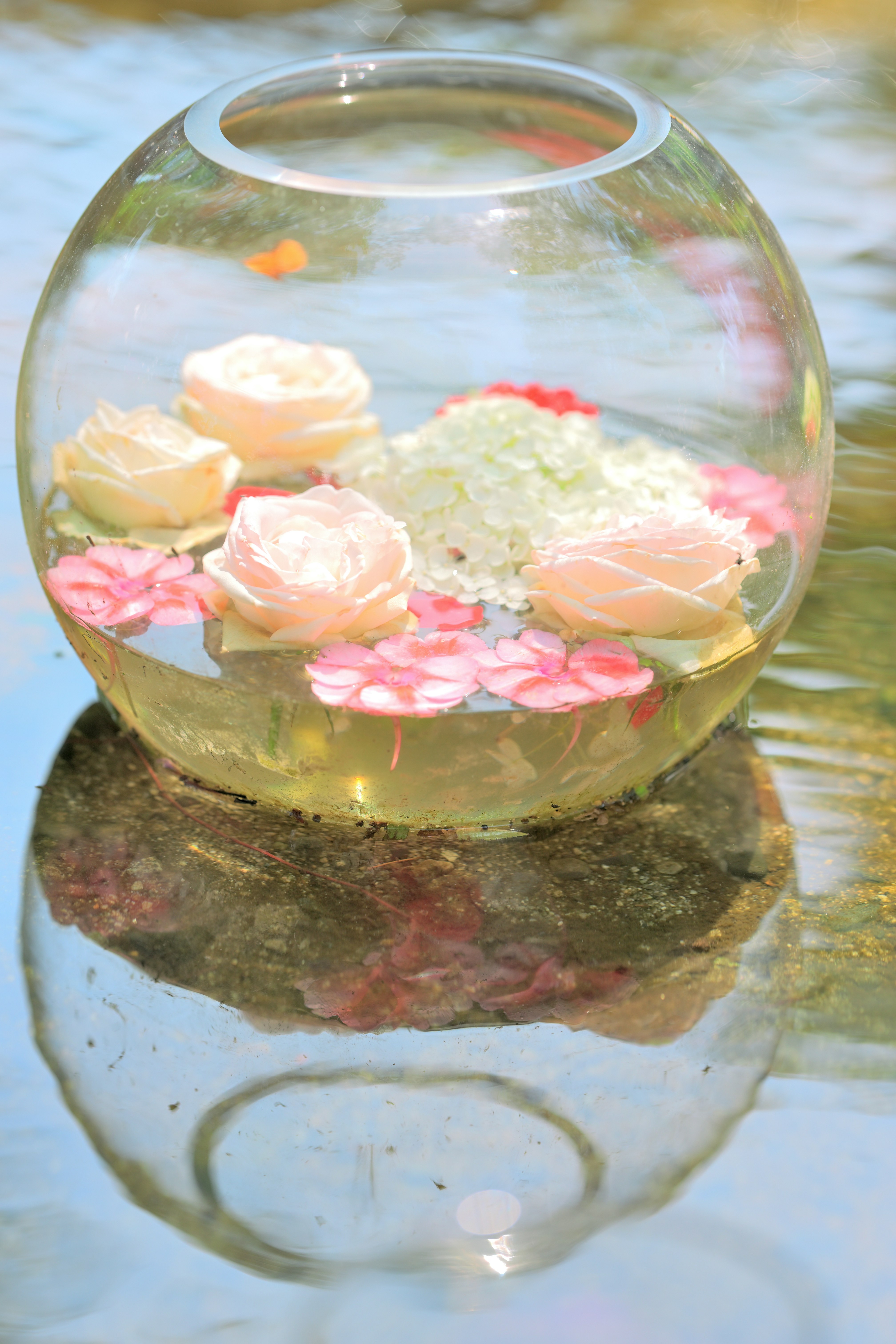 Glasvase mit bonbonartigen Deko-Elementen auf dem Wasser