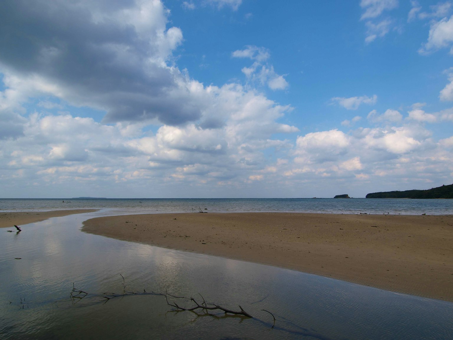 Pemandangan pesisir dengan langit biru dan awan putih pantai berpasir dan laut tenang