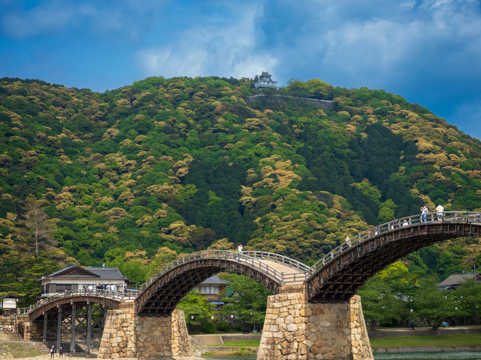 Ponte Kintai a Iwakuni circondato da colline verdi e cielo blu