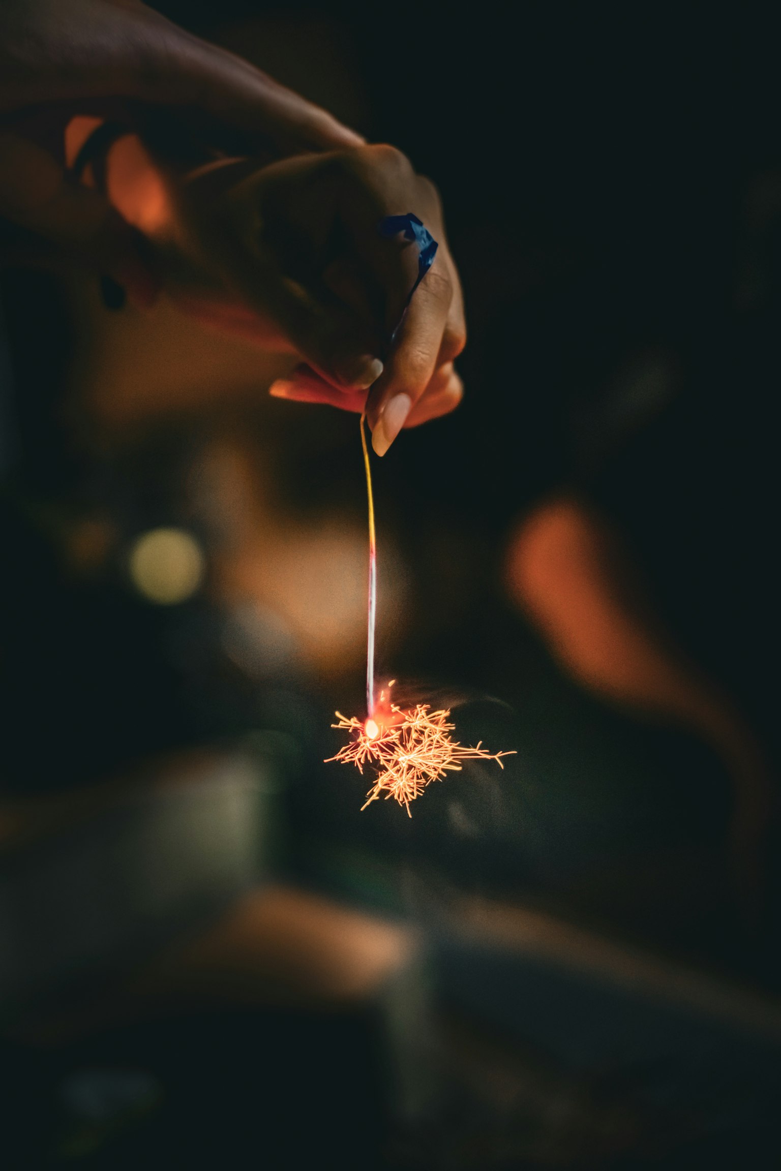 手に持たれた花火が輝いている夜のシーン