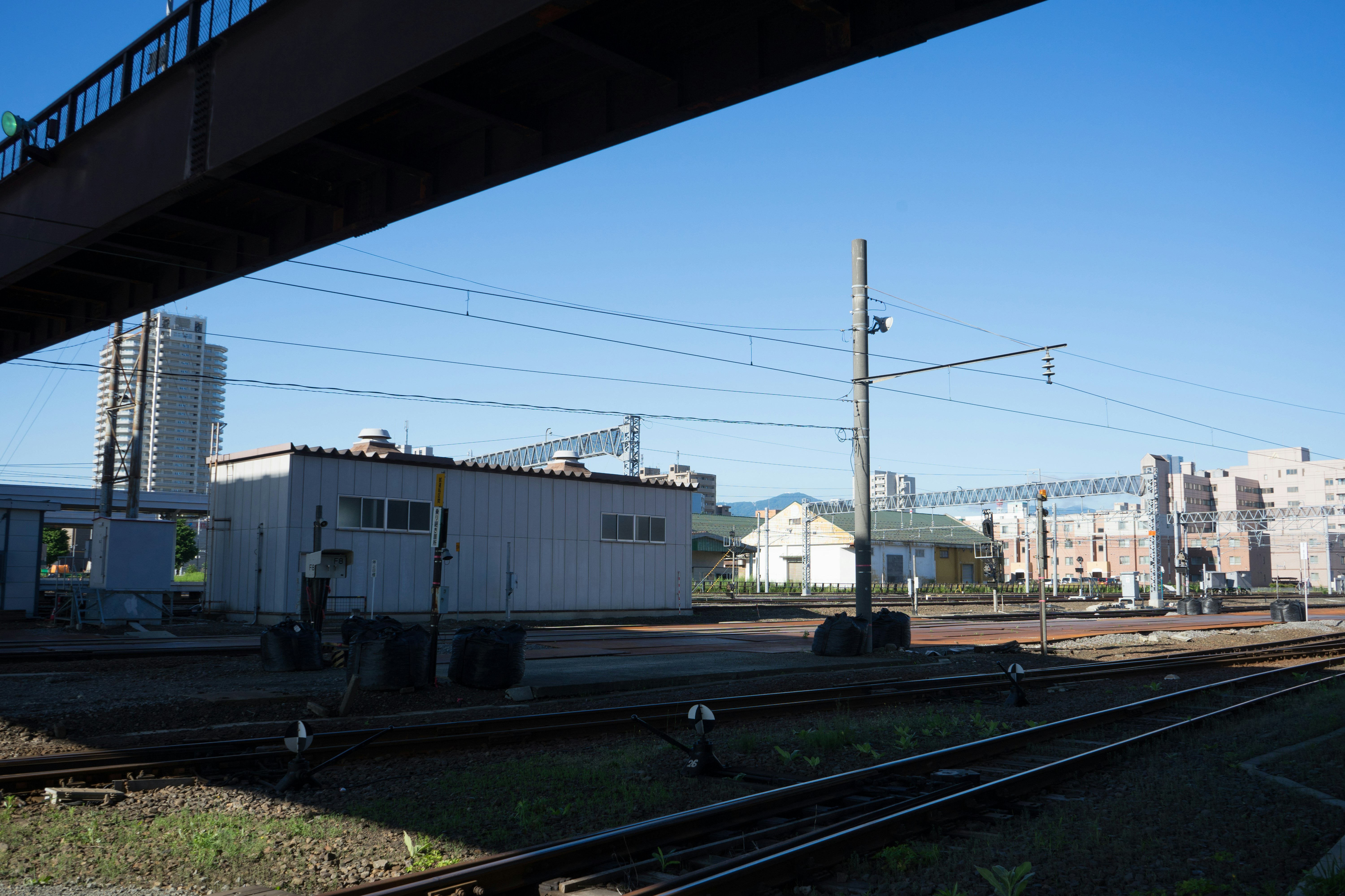 青空の下に広がる鉄道の景色 鉄道線路と建物が見える