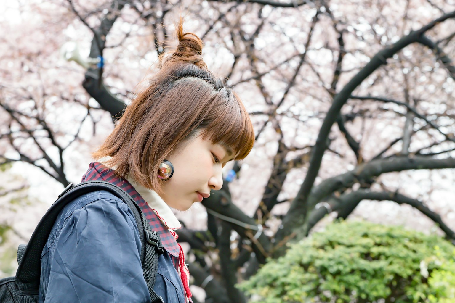 Une femme pensant sous un cerisier en fleurs