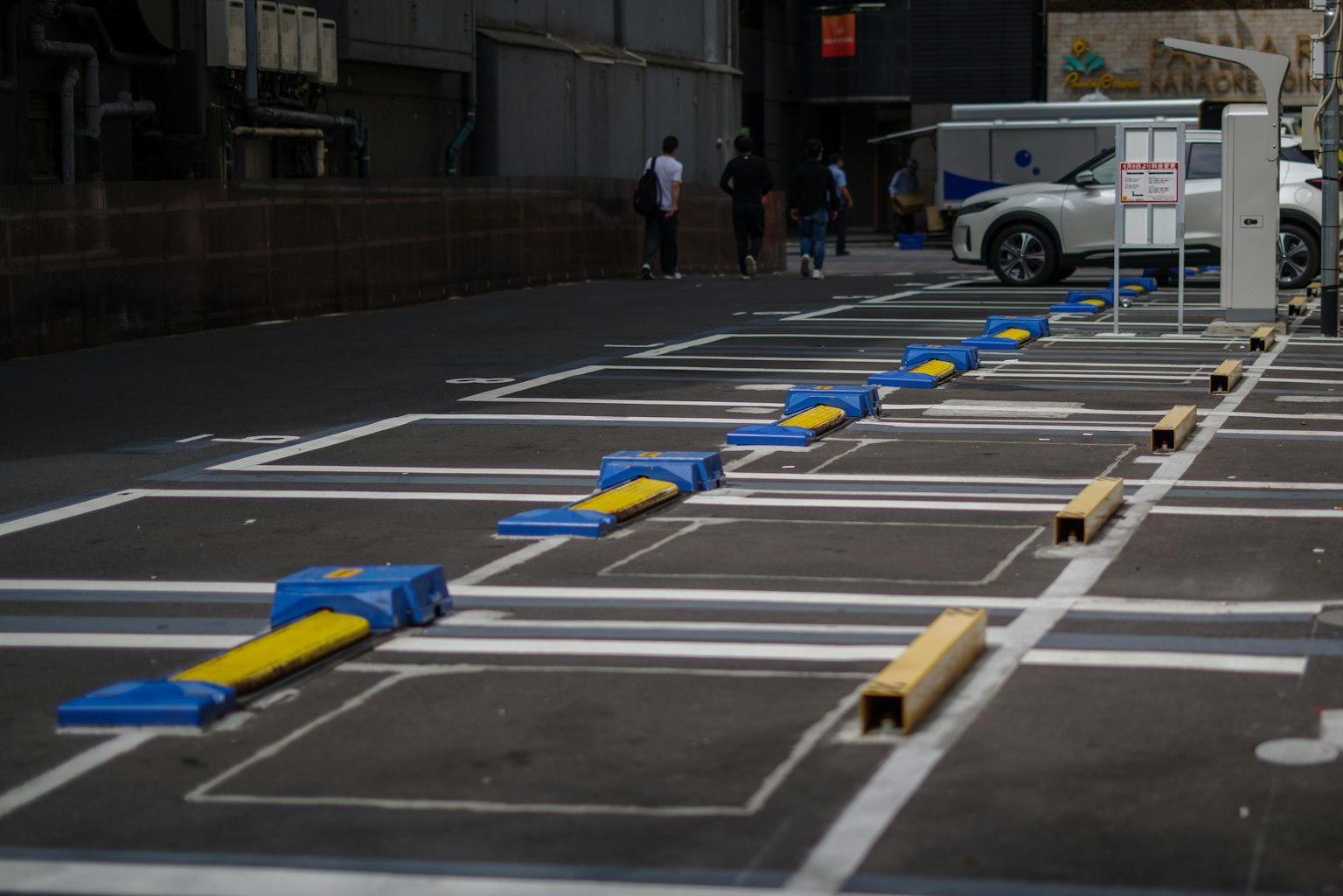 Estacionamiento con barreras azules y amarillas y espacios marcados