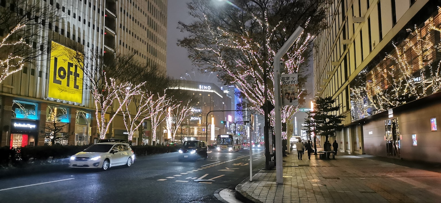 Una calle de la ciudad por la noche adornada con luces brillantes