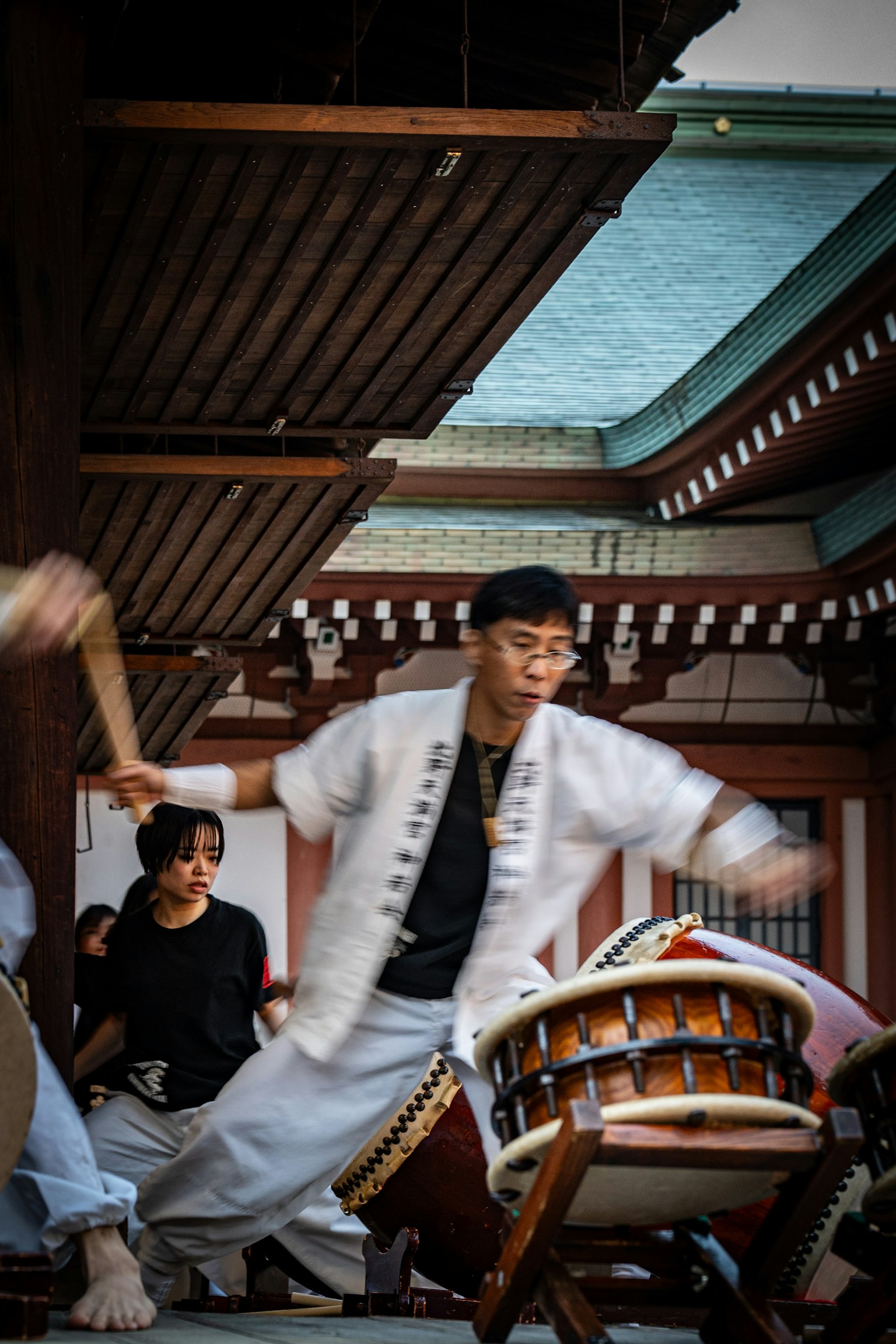 문화적 배경에서 전통 일본 타이코 드럼을 연주하는 남성 공연자
