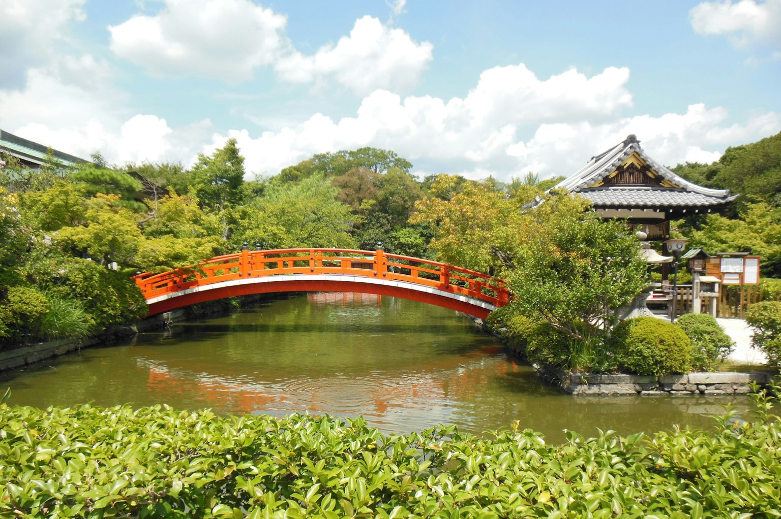 Scenic view of a red bridge over a pond in a Japanese garden