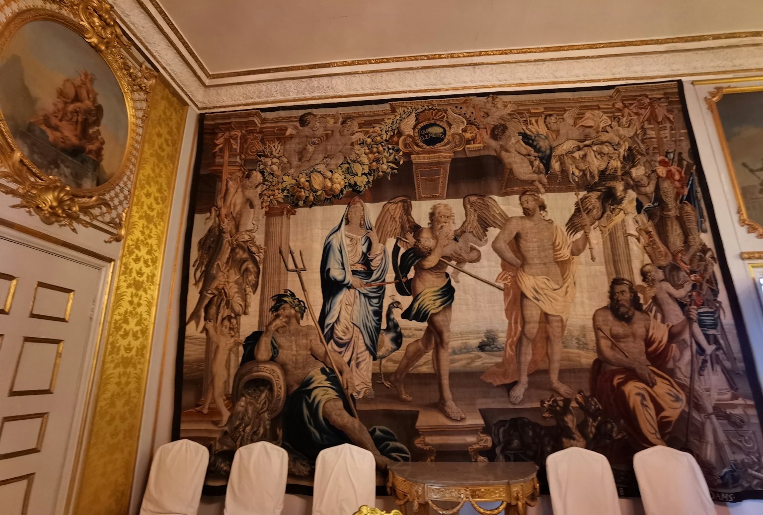 Sebuah bagian ruangan dengan permadani mewah Karya seni menggambarkan adegan dari mitologi kuno