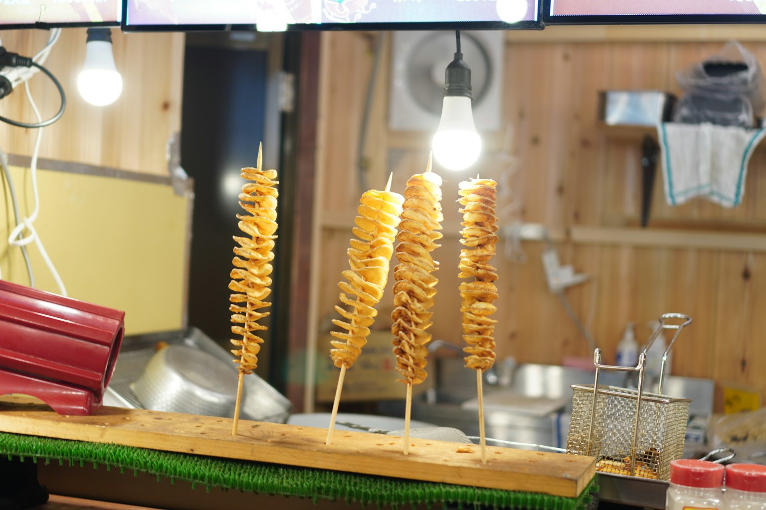 串に刺さった揚げたジャガイモのスナックが並ぶ屋台の風景