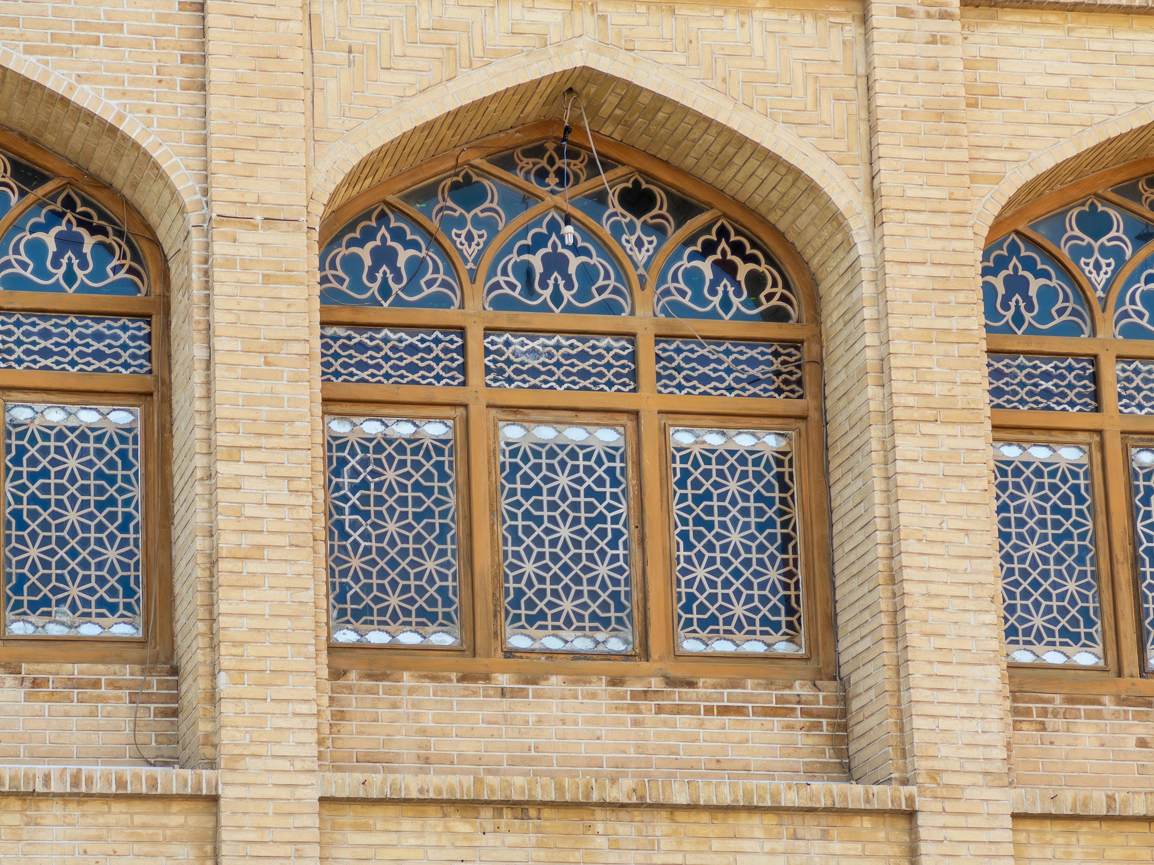 Brick building facade with arched window latticework