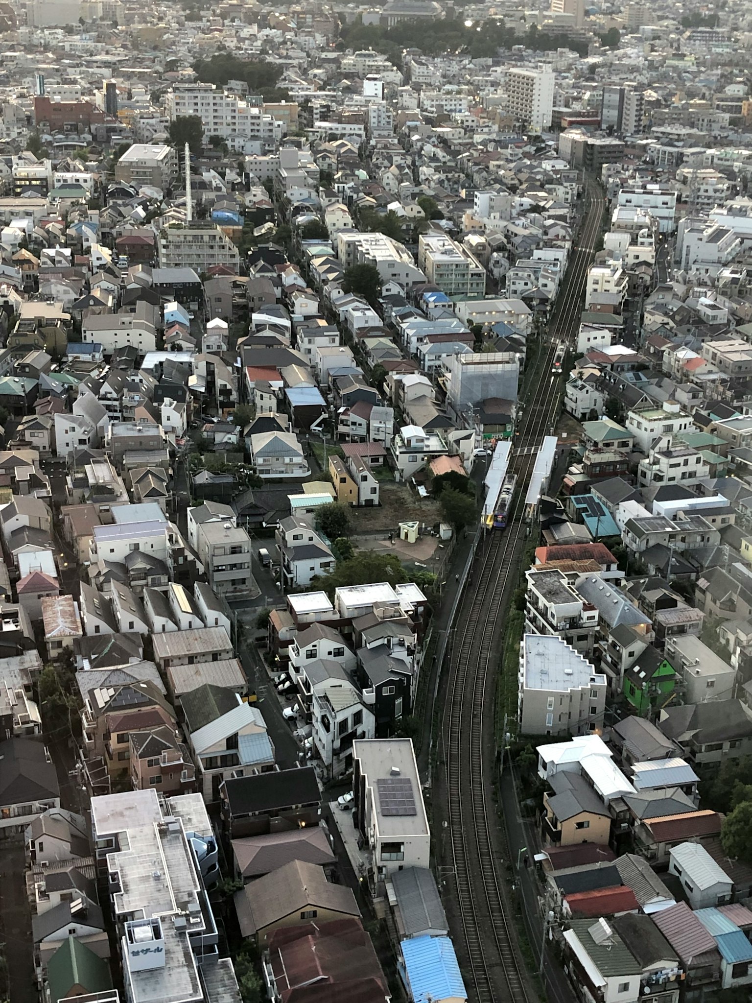 Vista aérea de un área residencial en Tokio con casas y una línea de tren