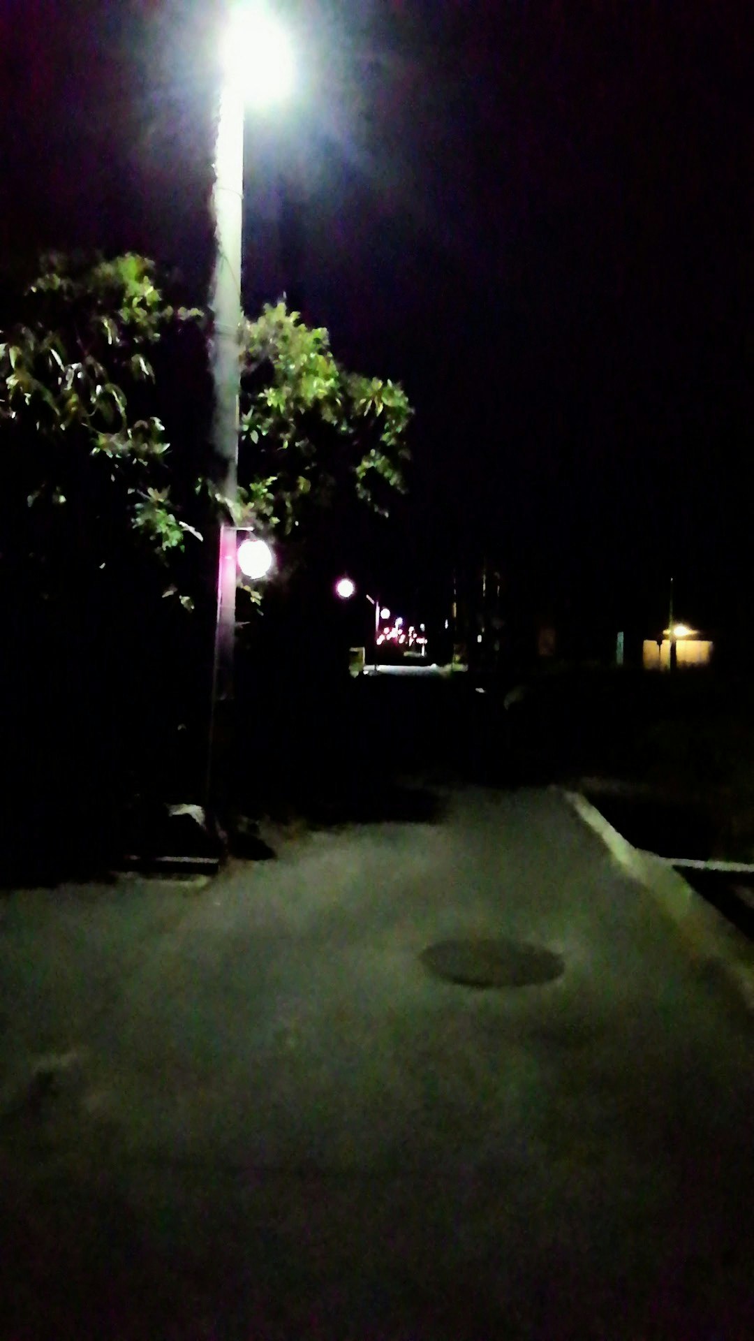 ถนนมืดในเวลากลางคืนส่องสว่างด้วยไฟถนนไปยังบรรยากาศเมืองเงียบๆ
