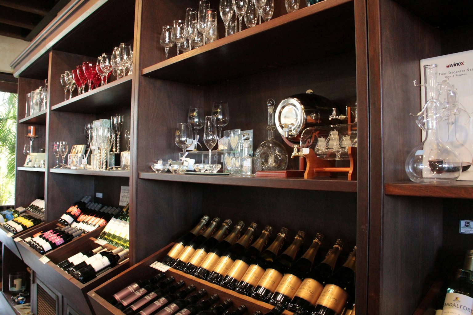 Bouteilles de vin et verrerie disposées sur des étagères en bois