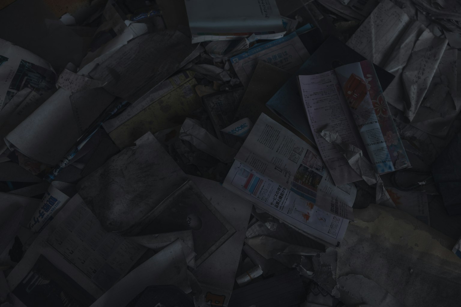 Scattered newspapers and magazines on a dark background