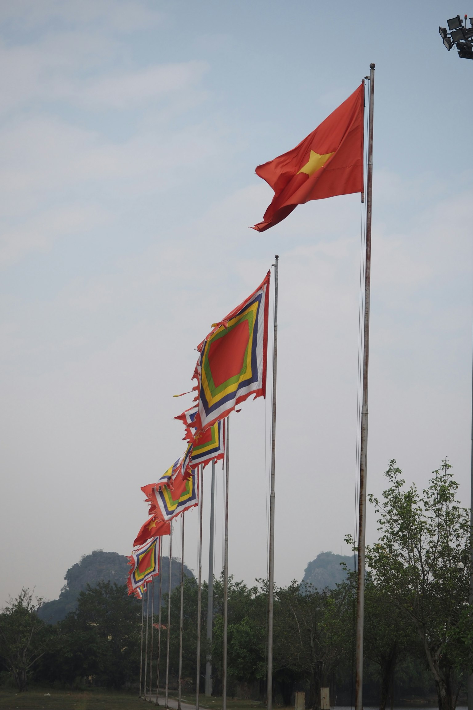 Fila de banderas rojas vietnamitas con un fondo montañoso