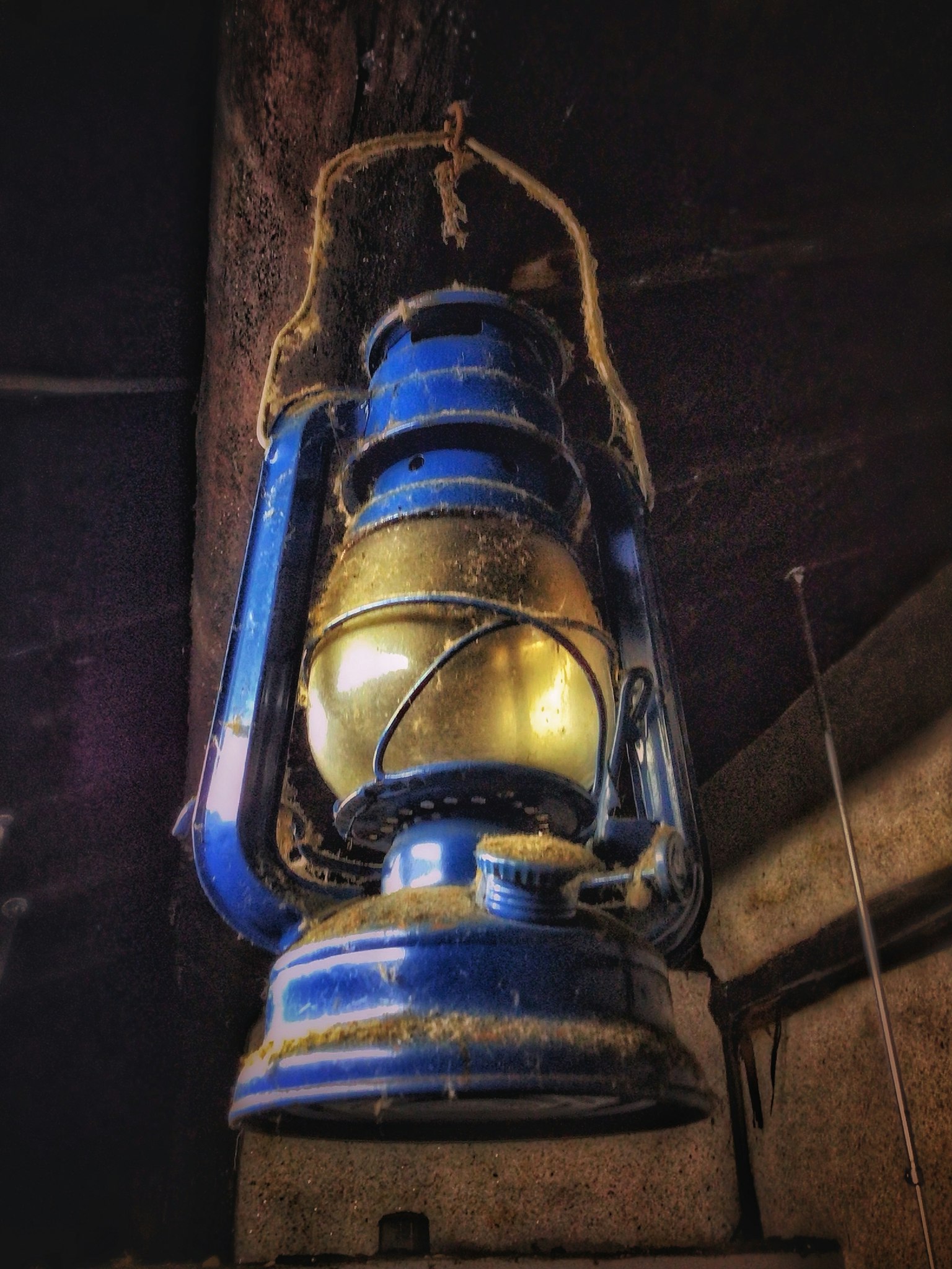 Blue lantern hanging against a dark background