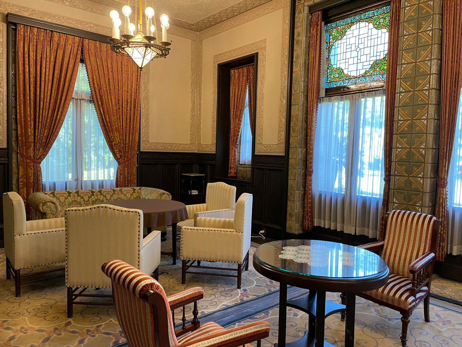Classic interior living room with curtains, chairs, table, decorative window