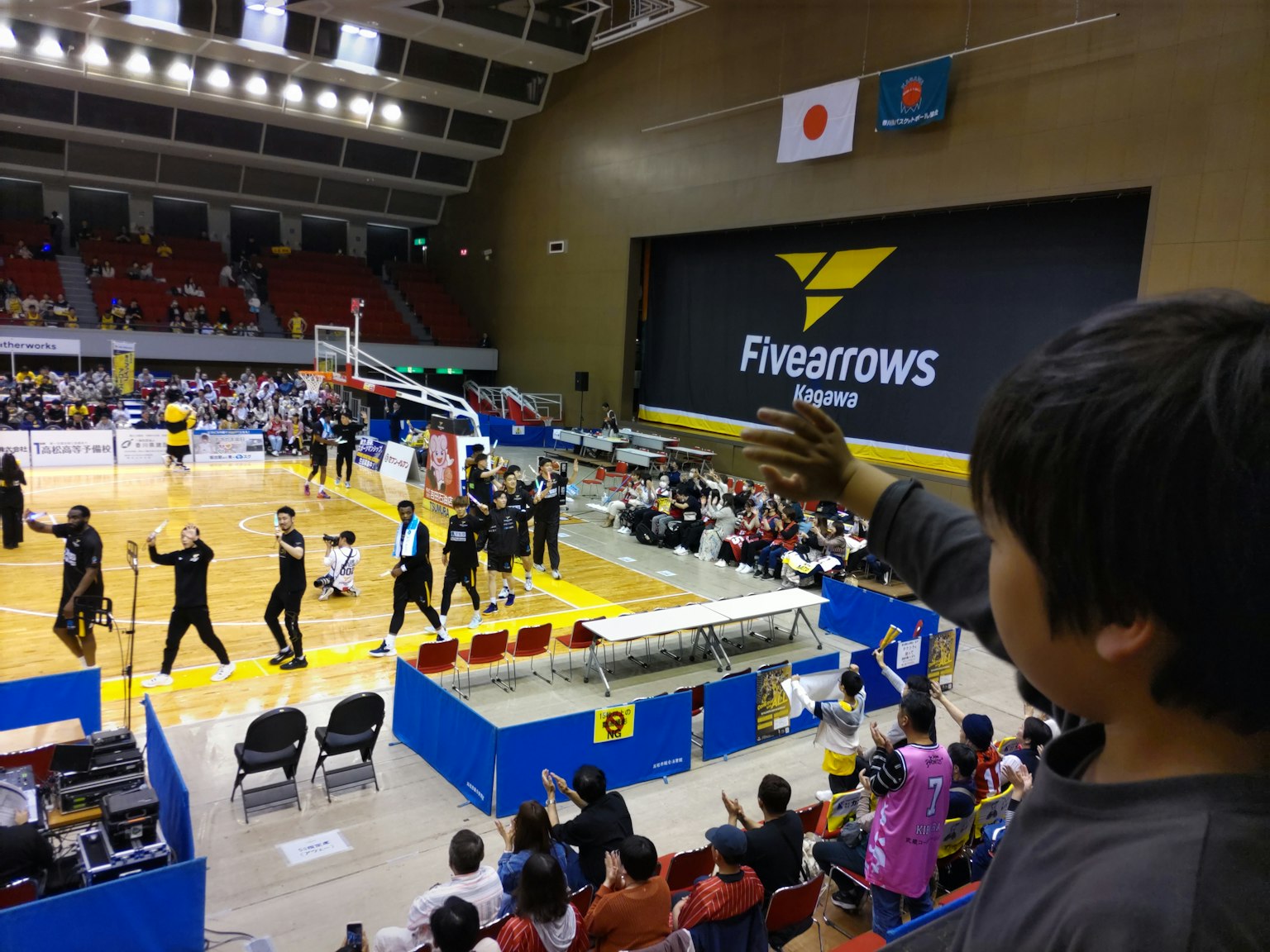 Pubblico che guarda una partita di basket in un'arena sportiva