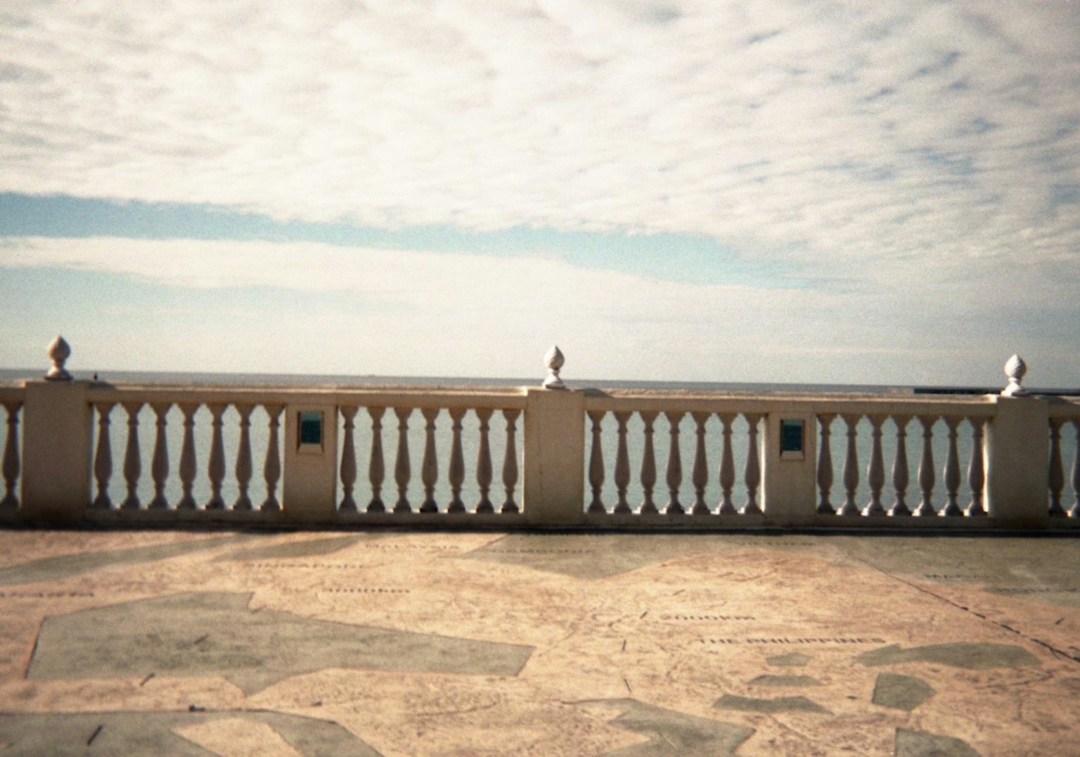 Balcony railing overlooking the sea with a cloudy sky