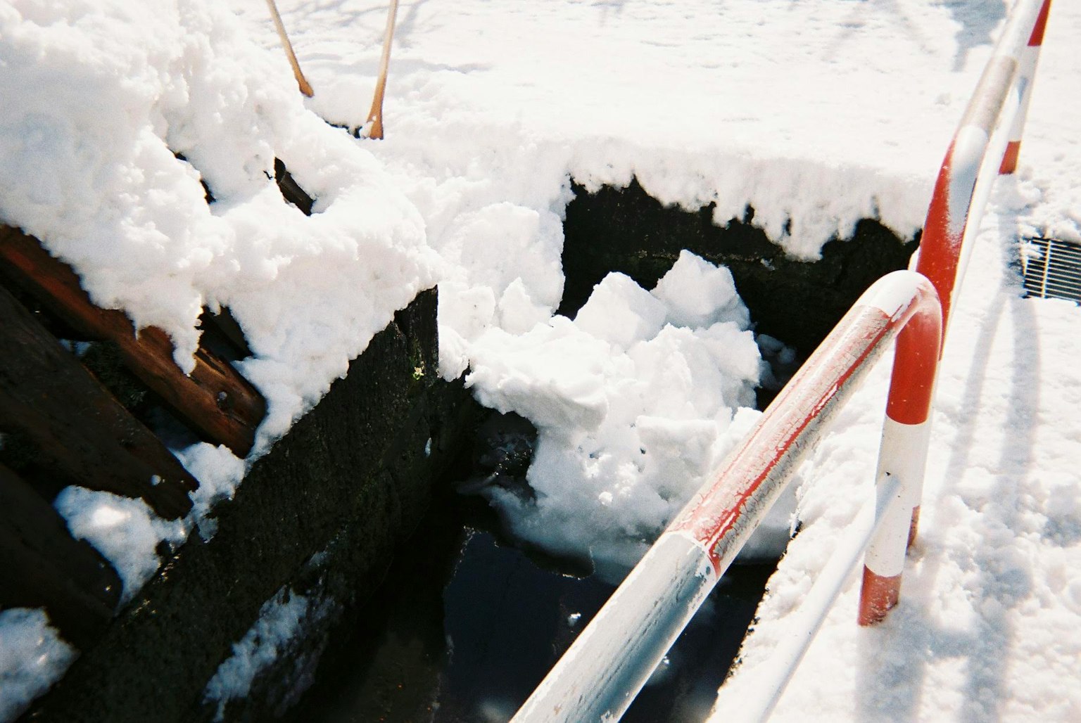 被雪覆盖的沟渠和红白栏杆