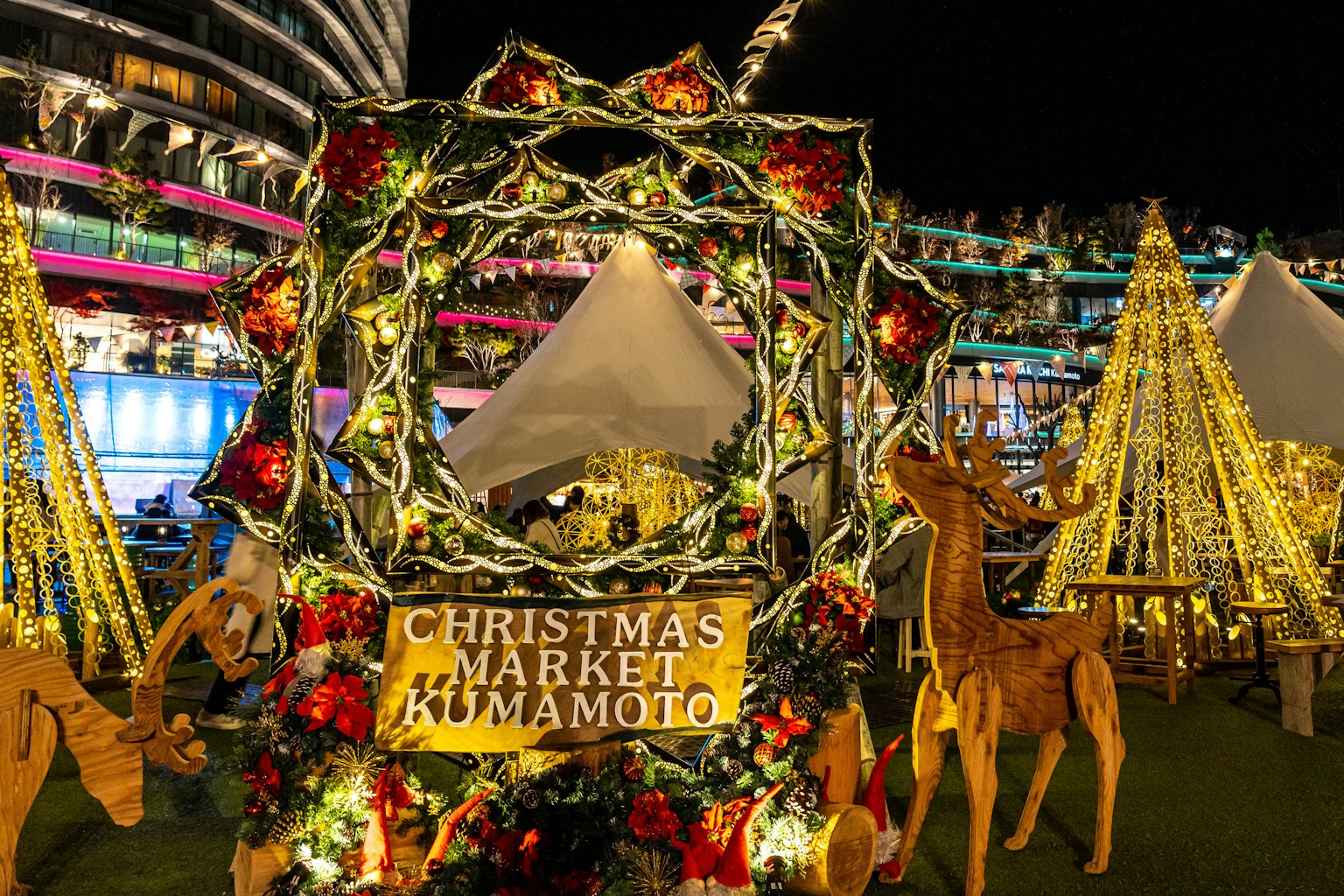 Vista nocturna del mercado navideño de Kumamoto con decoraciones festivas
