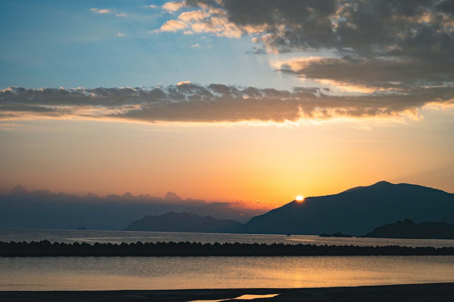 Sonnenuntergang über einem Berg mit ruhigem Meer