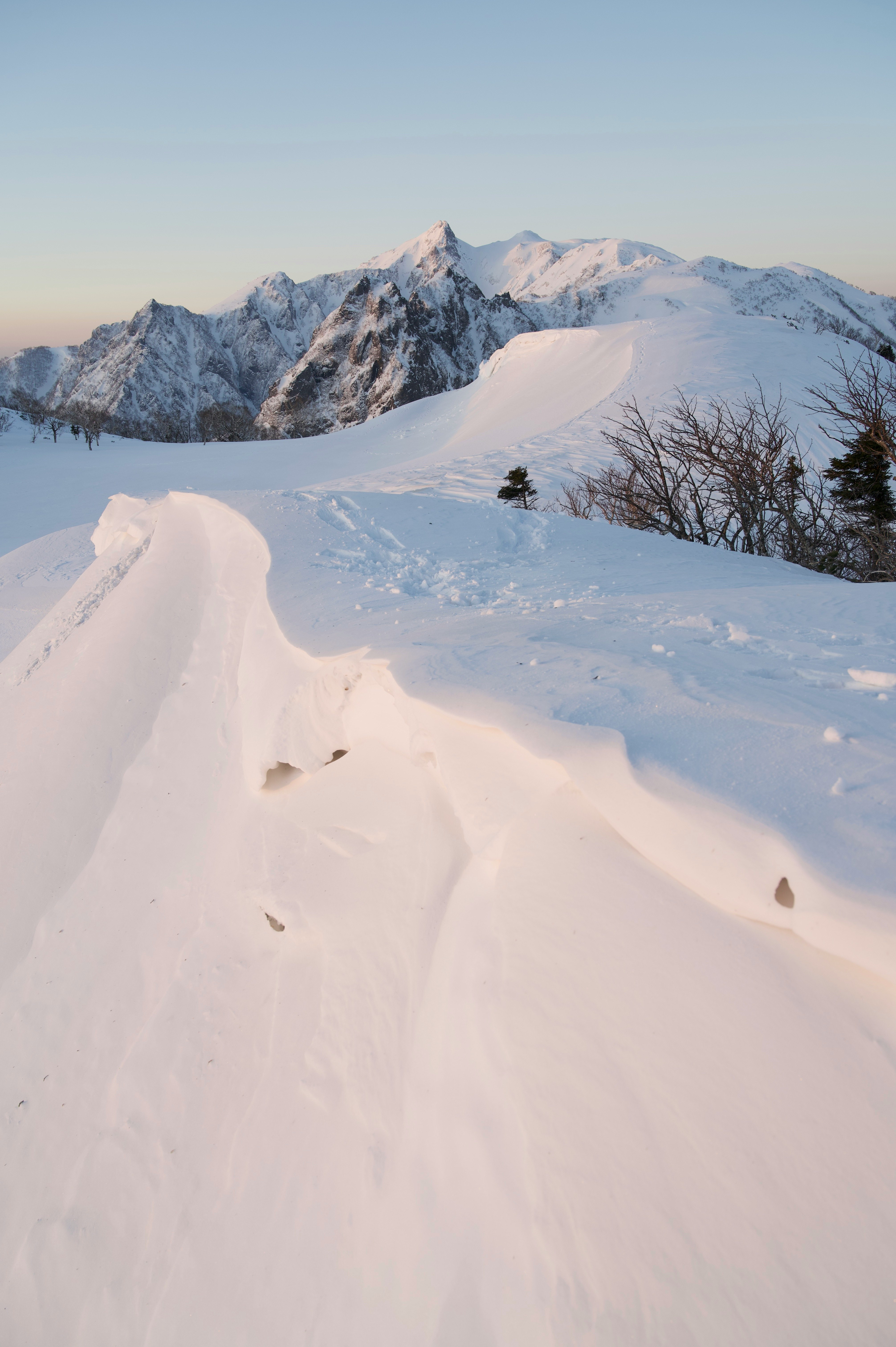雪の稜線を続くワイルドなトレイルと山並みの眺望