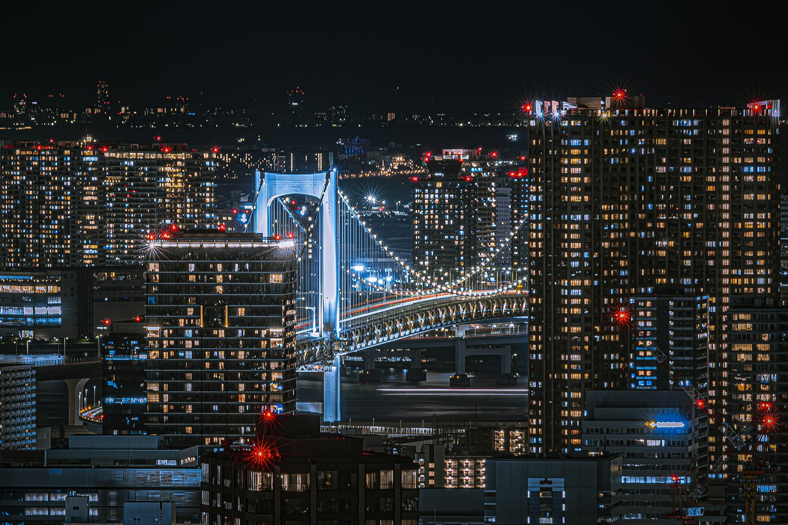 Pemandangan malam yang indah dari Jembatan Pelangi di atas Teluk Tokyo dengan gedung pencakar langit