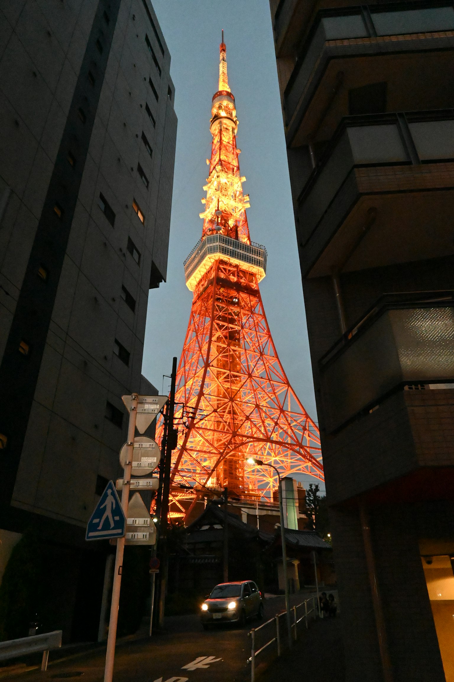 La tour de Tokyo brillait en orange au crépuscule entre les bâtiments
