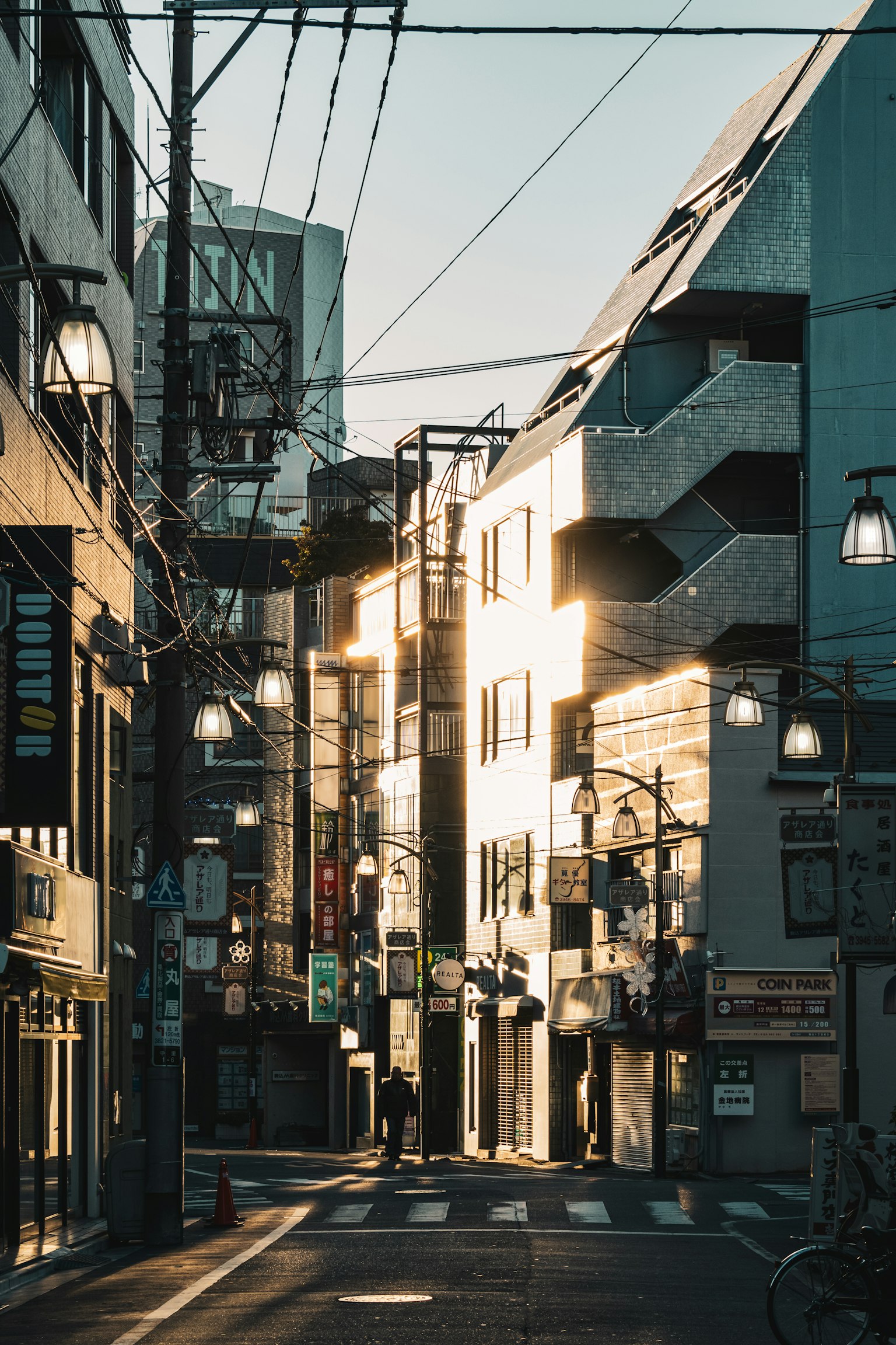 街道景观，建筑反射夕阳光，街灯亮起
