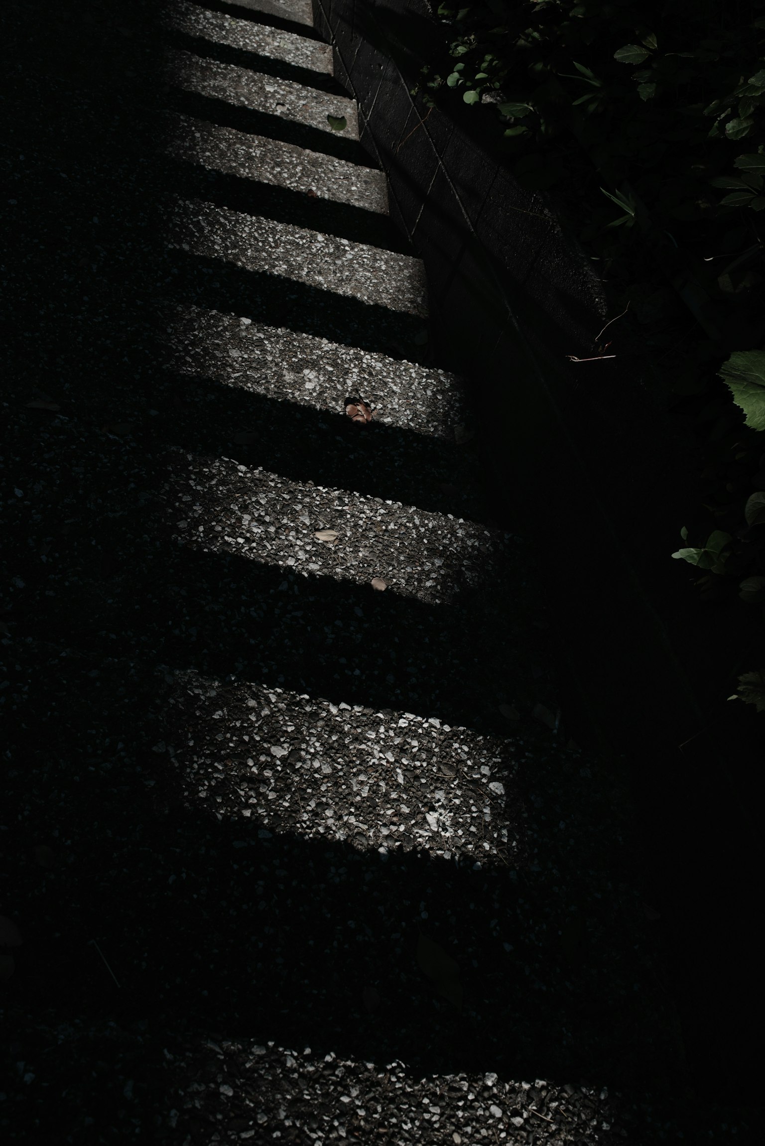 Staircase shadows and light patches on a dark background