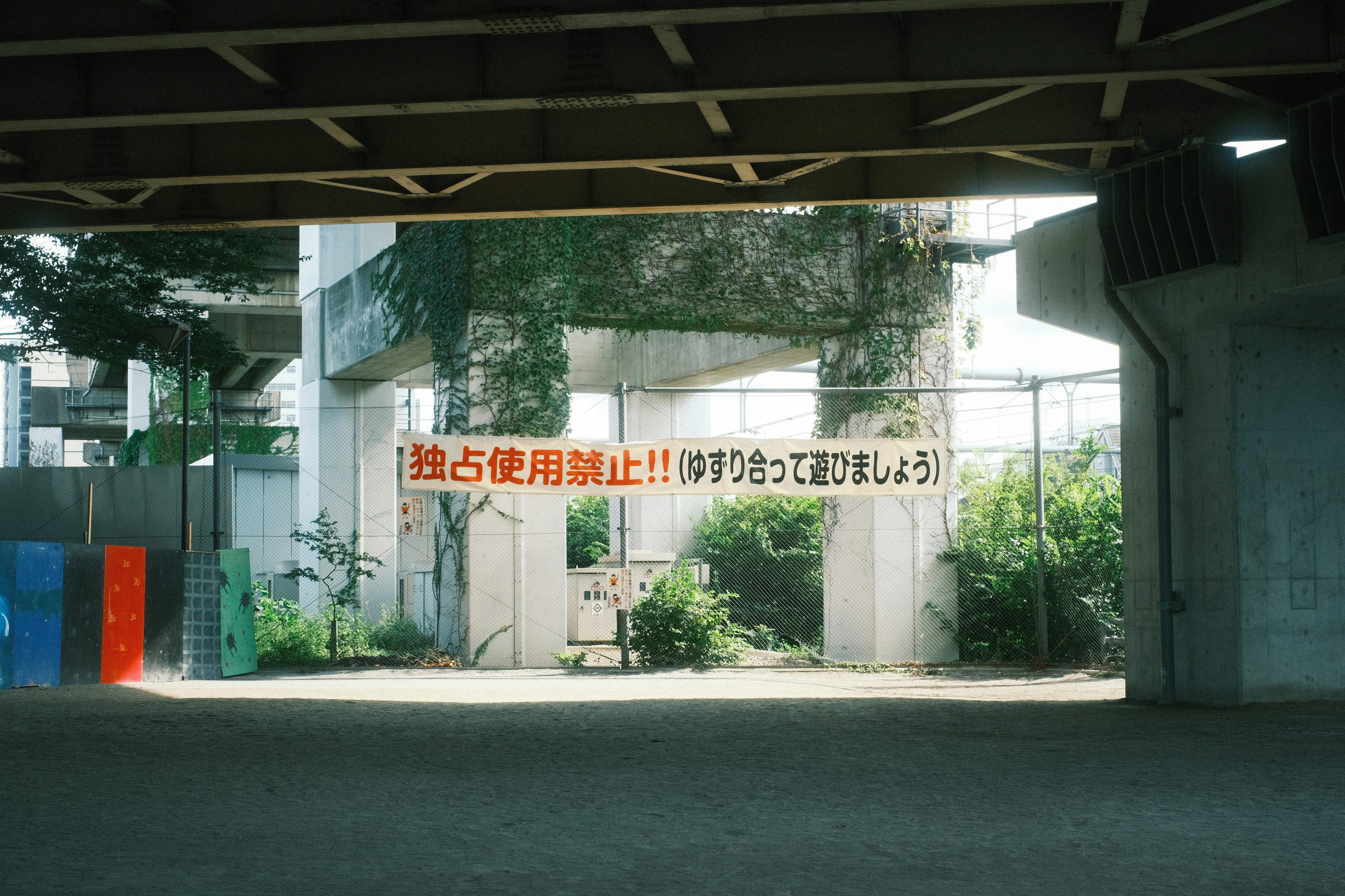 高架下の通路に掲示された注意表示のある空間