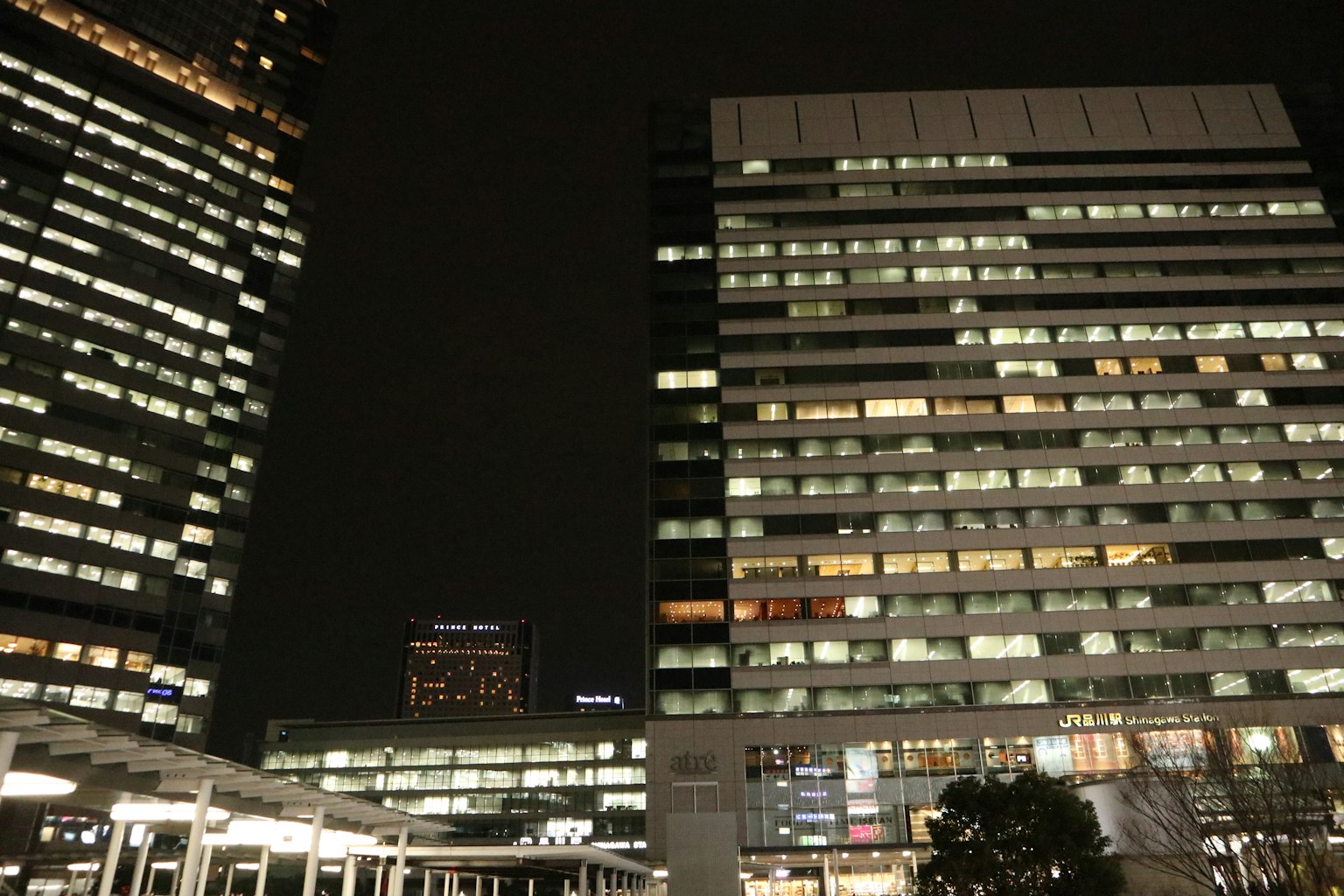 Paysage urbain nocturne avec des gratte-ciels illuminés et des fenêtres de bureaux