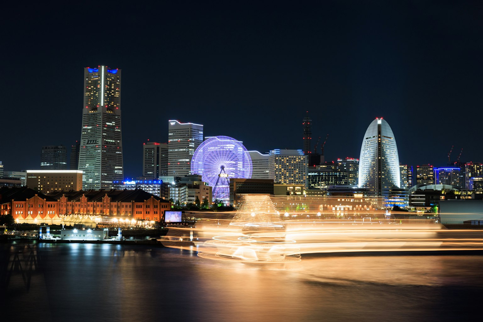横滨的夜景现代建筑和明亮的灯光港口的船只移动