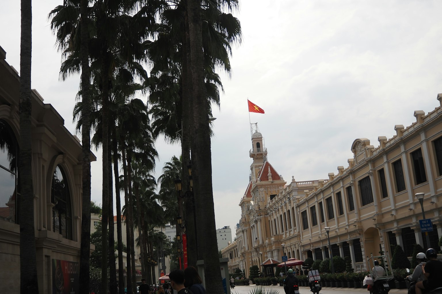 Street view of Ho Chi Minh City with palm trees and historic architecture
