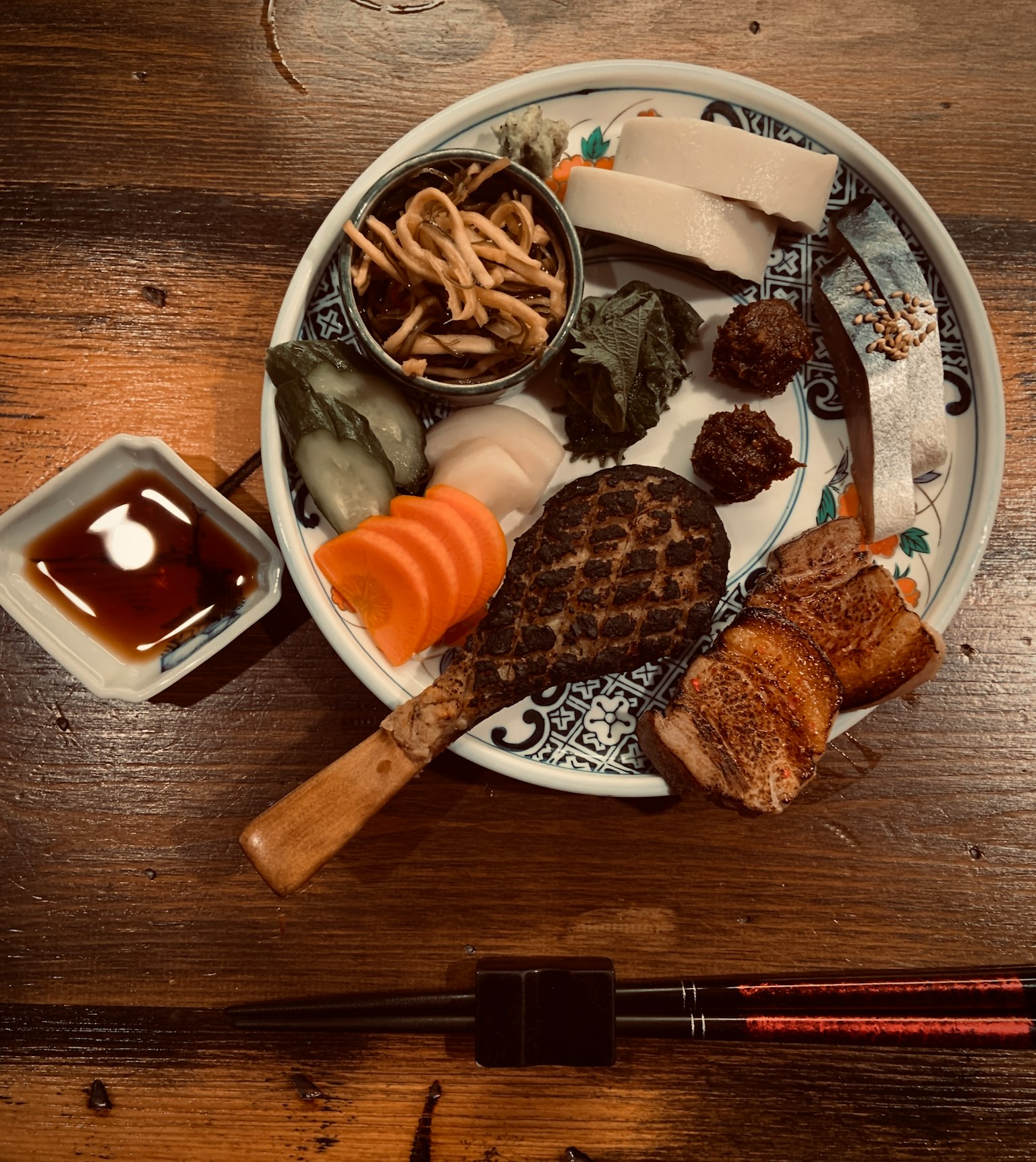 Une assiette de cuisine japonaise assortie avec de la sauce soja à côté