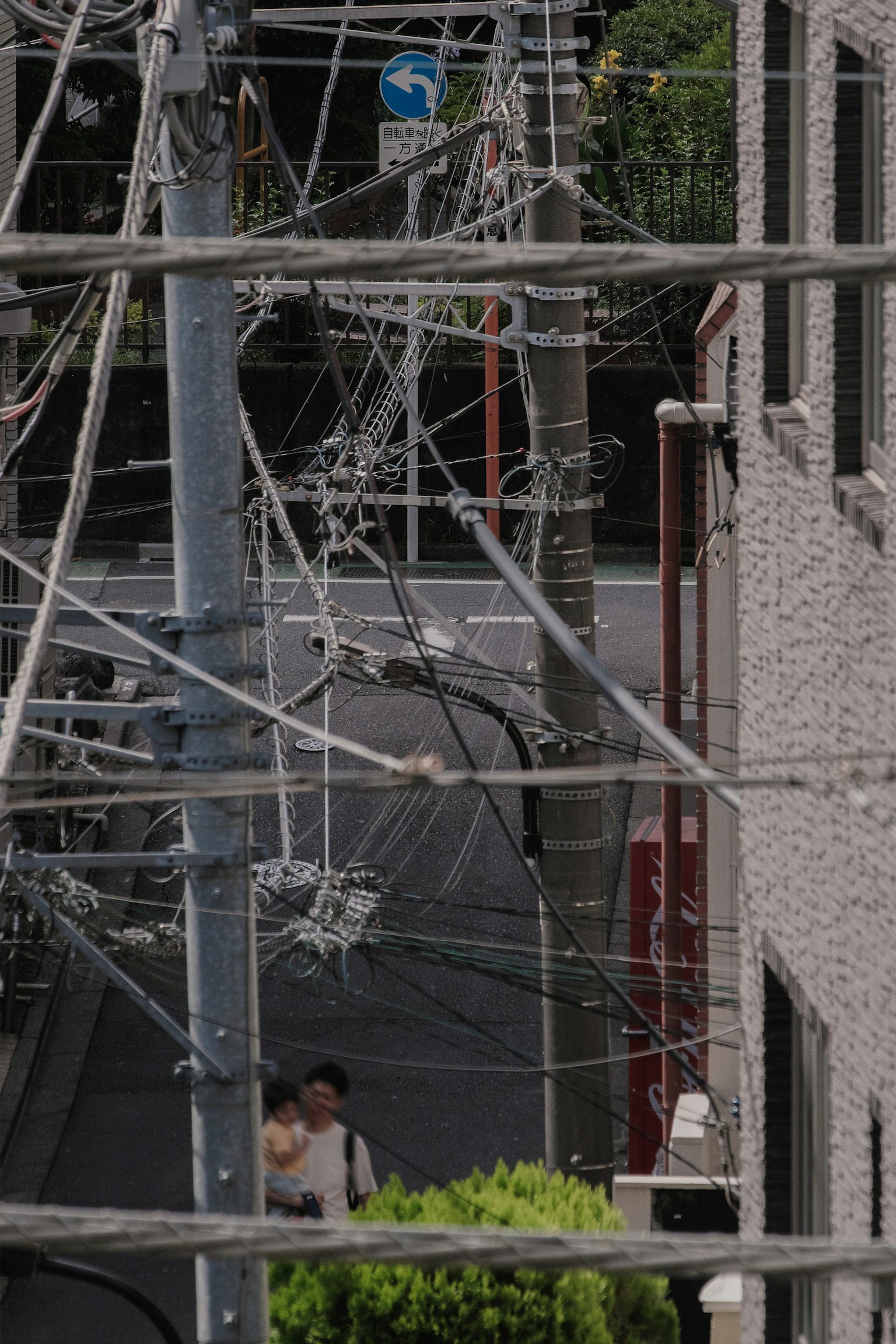 Pemandangan perkotaan dengan kabel listrik bersilangan dan pejalan kaki