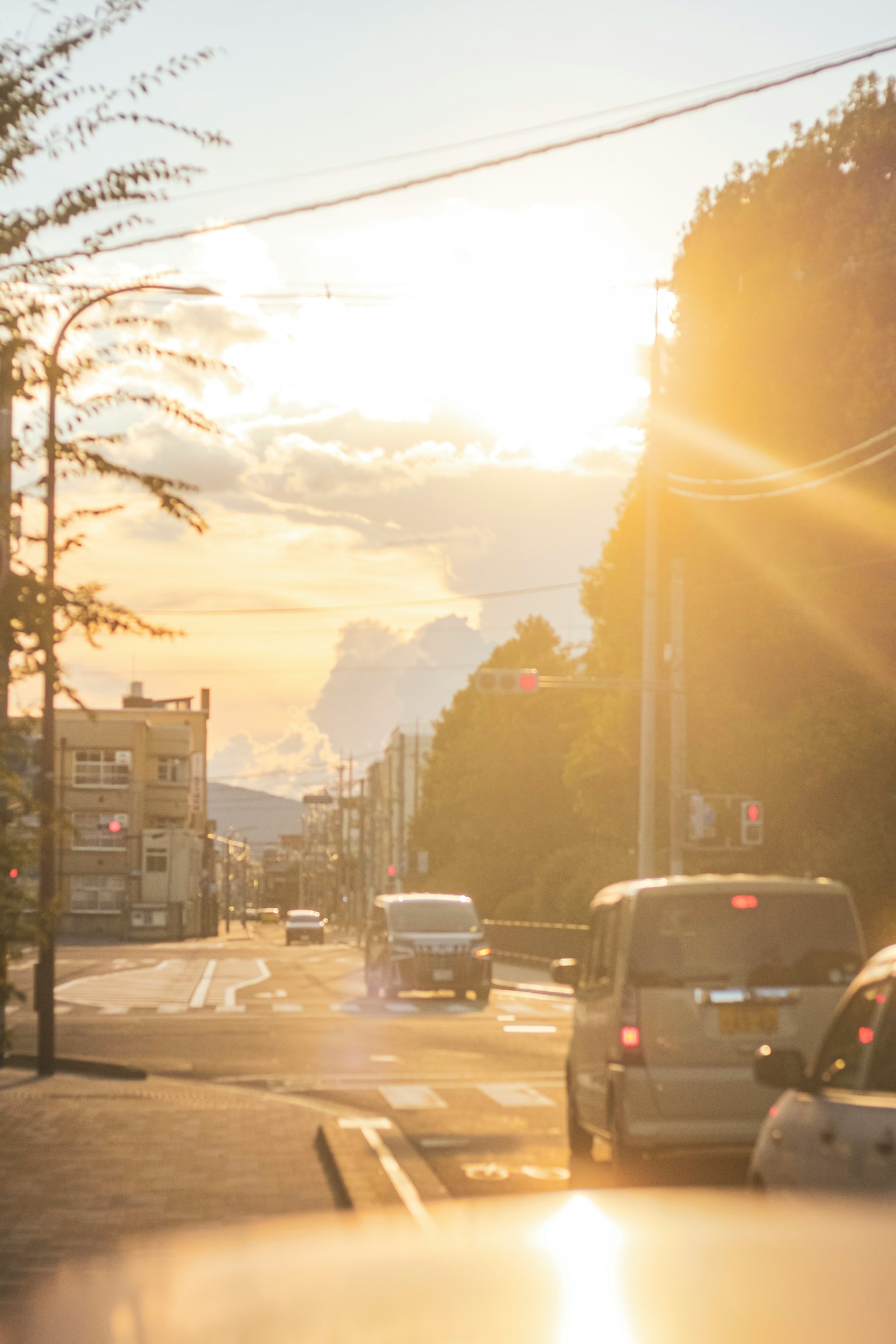 阳光透过云层的道路场景 街上的汽车