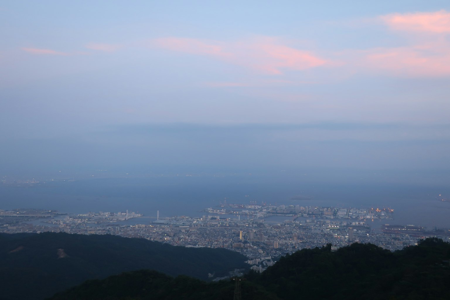 Vista panoramica del mare e della città al crepuscolo da una montagna
