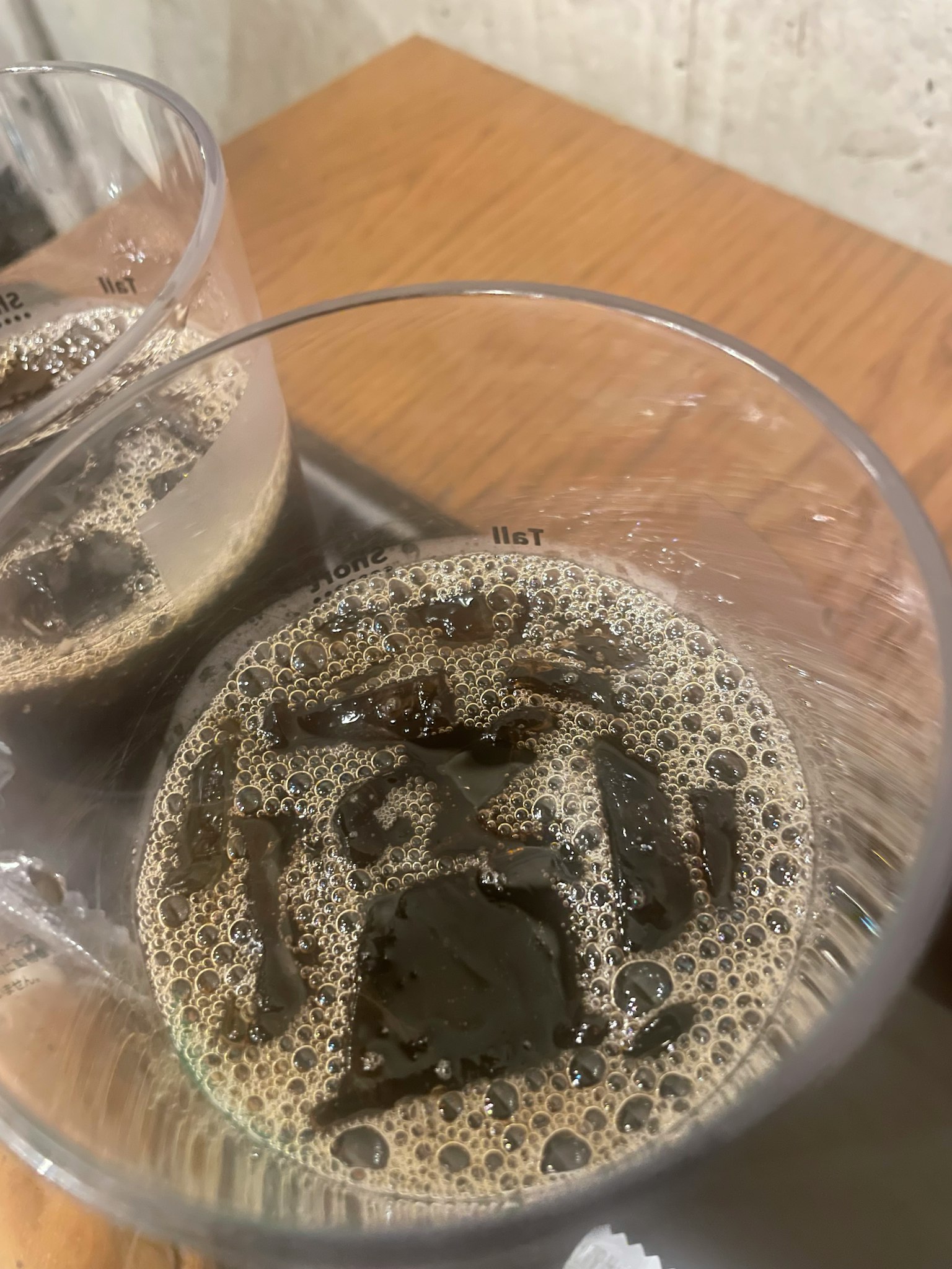Deux verres transparents remplis d'une boisson sombre et pétillante avec des glaçons
