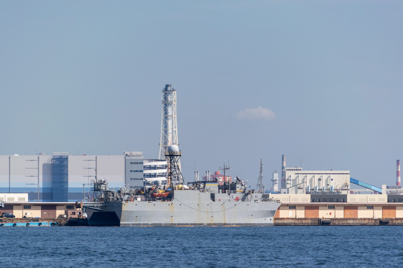 Großes Schiff im Hafen mit Industriegebäuden im Hintergrund