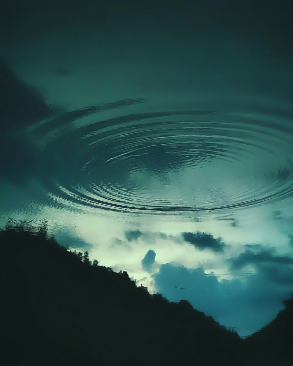 水面の波紋と空の反射が重なる逆さの空景