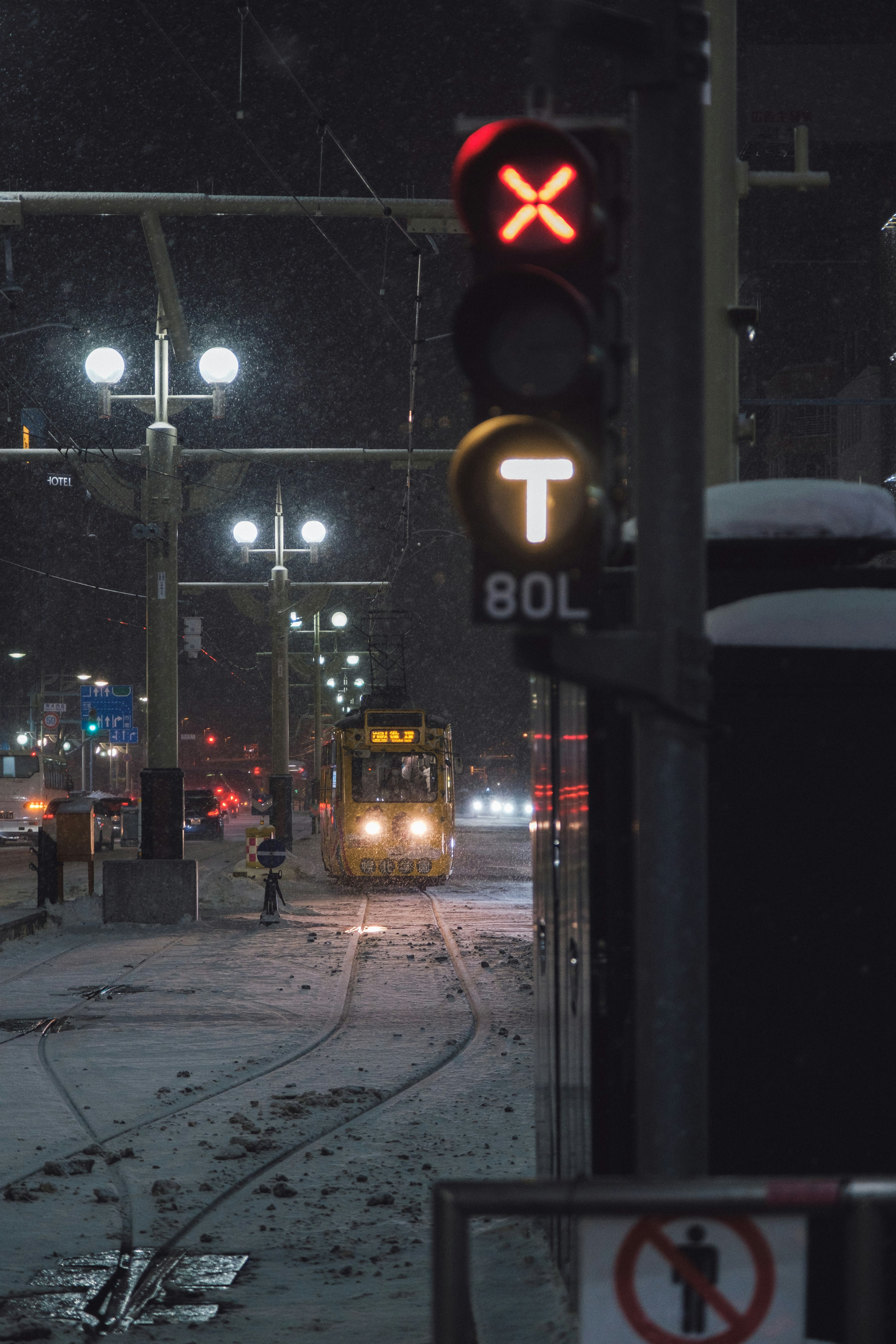 雪の路面電車が走る夜の交差点