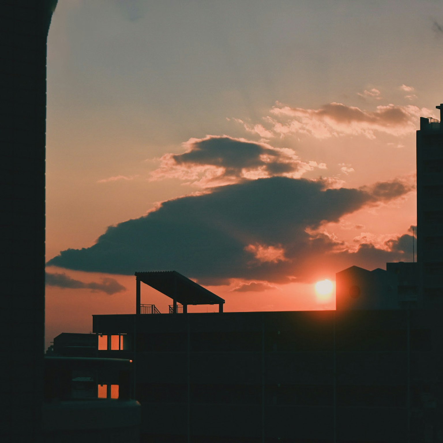 Silhouette d'une ville au coucher du soleil avec des nuages et le soleil