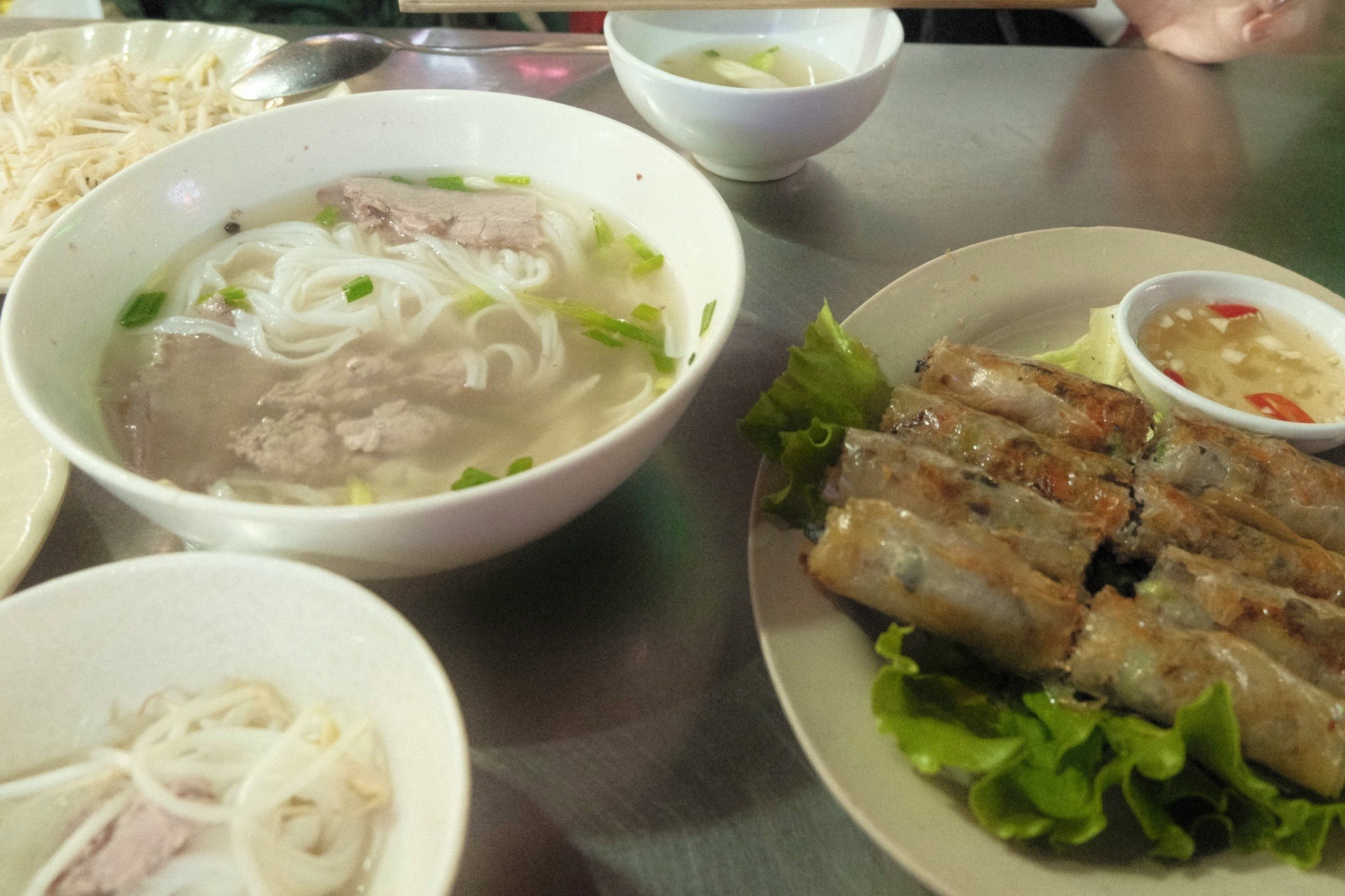 Ein Tisch mit Pho und frischen Frühlingsrollen mit Dip-Sauce