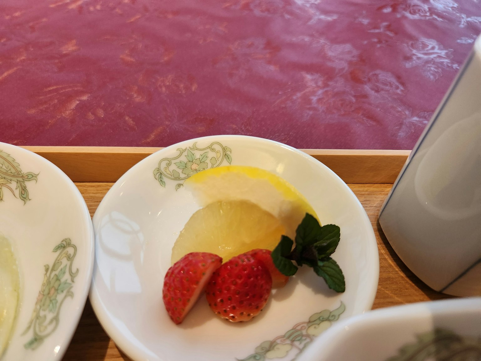 Dessert plate featuring strawberries lemon slices and mint leaves