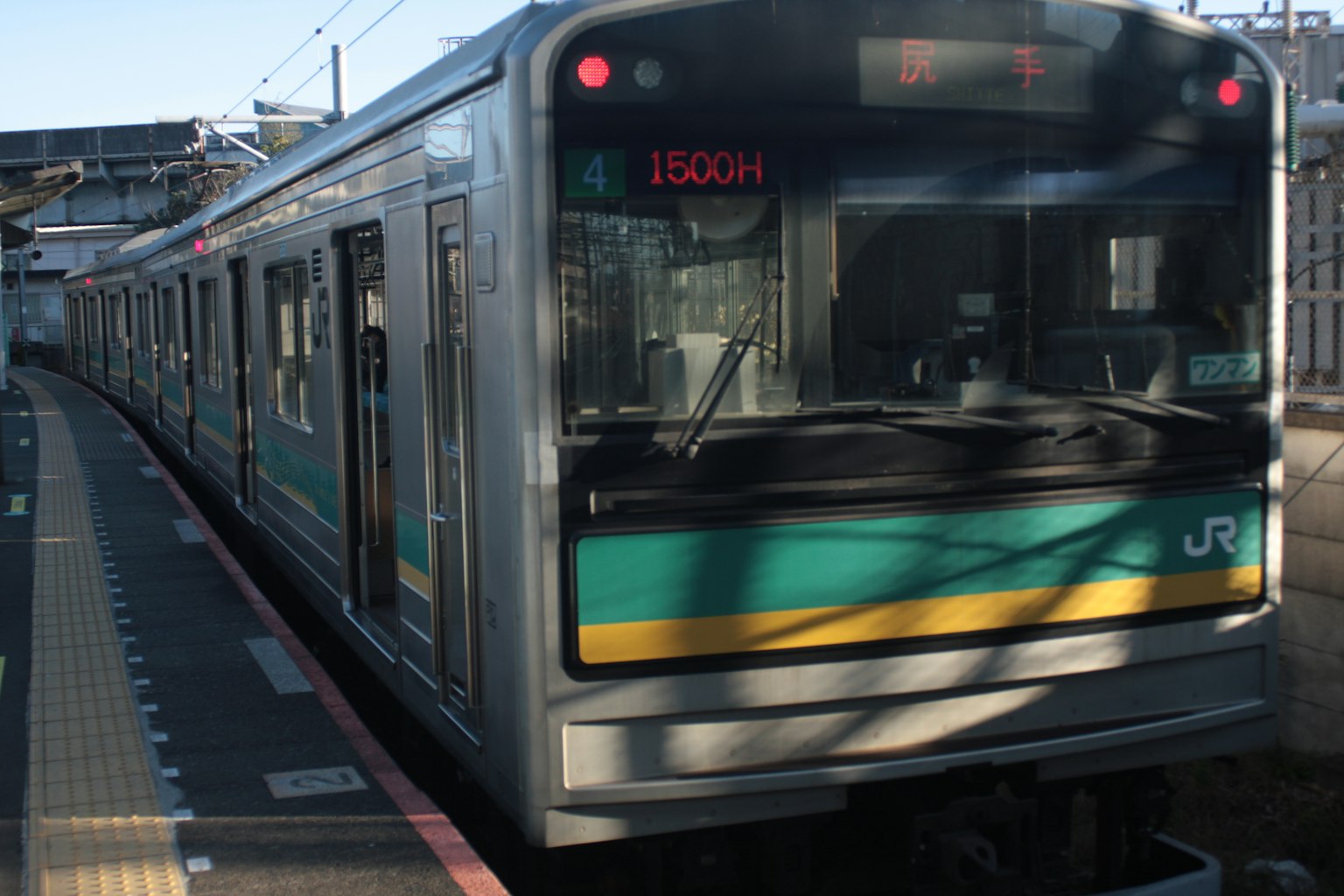 Treno JR verde e argento fermo in stazione