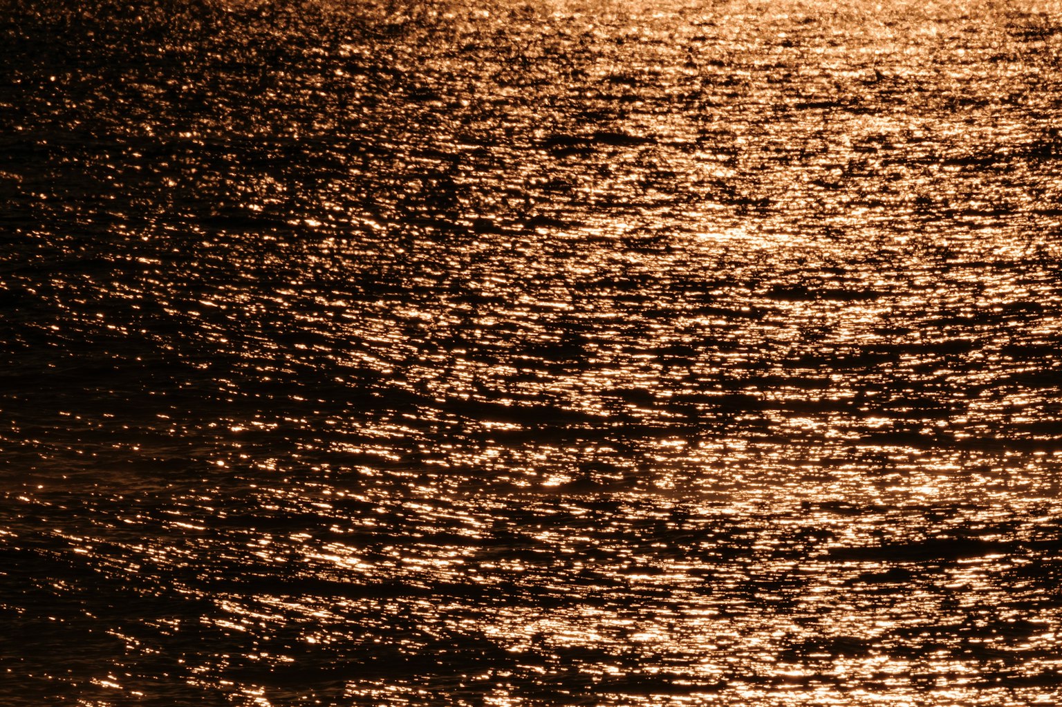 Welliges Meer, das das Licht des Sonnenuntergangs reflektiert