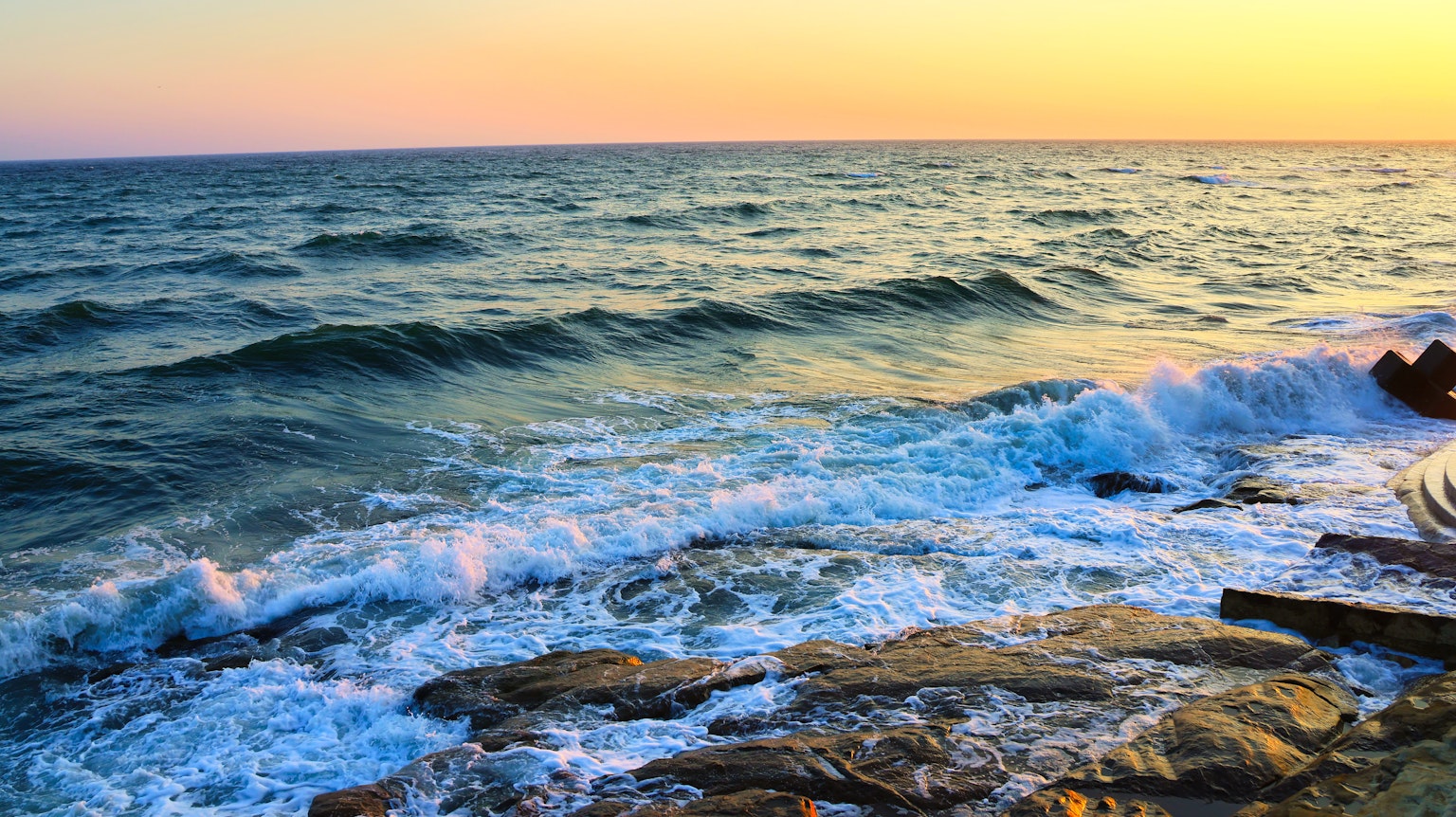 美麗的海上日落波浪拍打岩石
