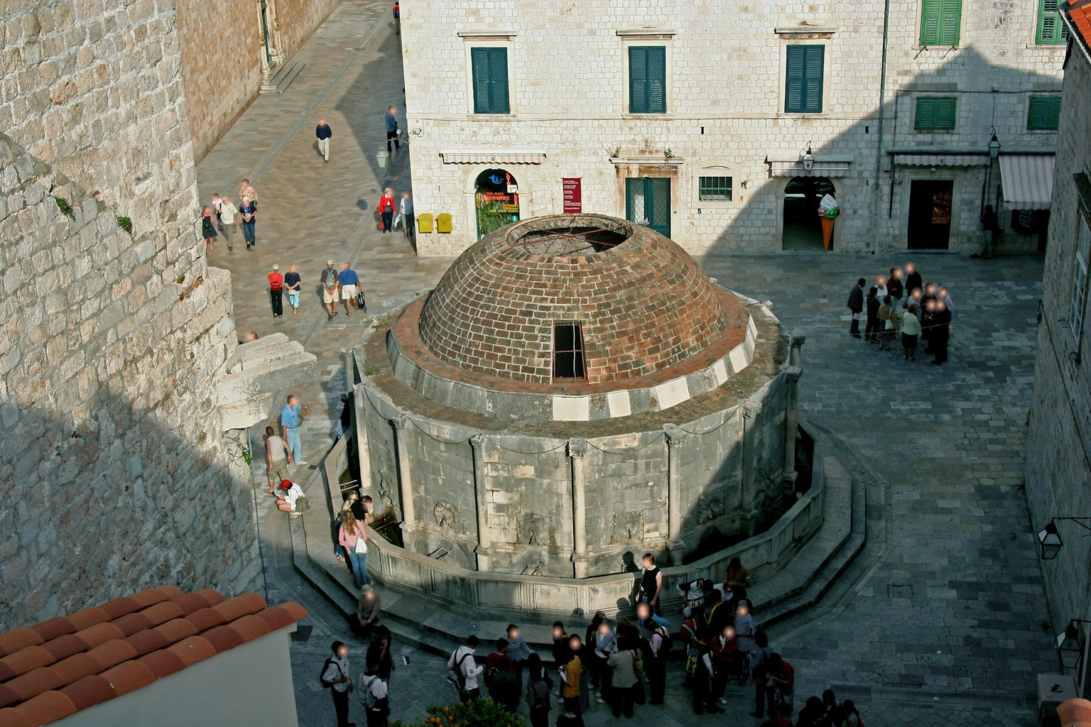 Fontaine circulaire à Dubrovnik avec une architecture médiévale entourée de touristes